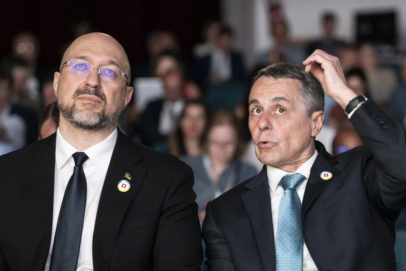 Swiss President Ignazio Cassis, Minister of Foreign Affairs, right, and Ukrainian Prime Minister Denys Shmyhal, left, speak before taking the stage during the Economic Forum official opening following the Ukraine Recovery Conference URC, Tuesday, July 5, 2022 in Lugano, Switzerland. The URC is organised to initiate the political process for the recovery of Ukraine after the attack of Russia to its territory. (KEYSTONE/EDA/Alessandro della Valle)
