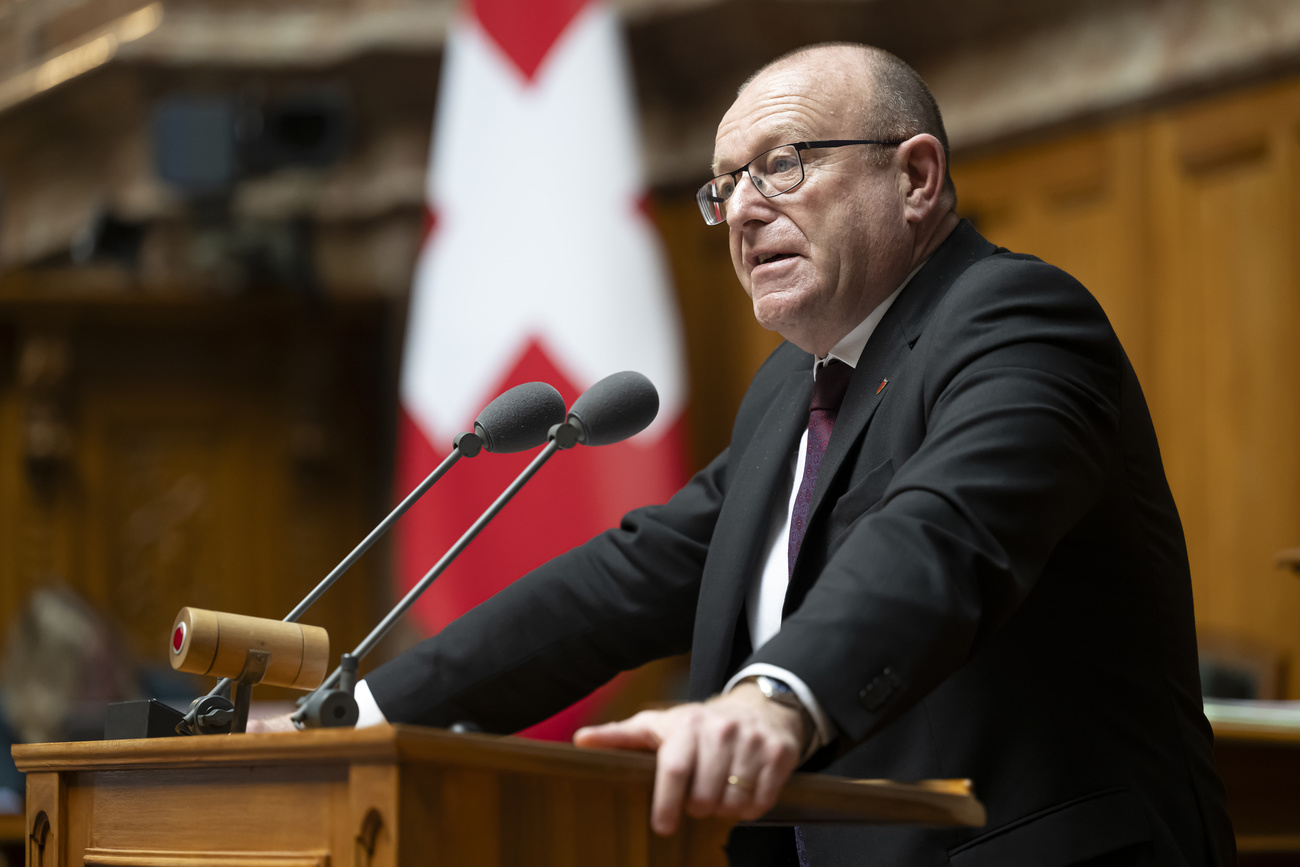 Homme s'exprimant à la tribune du Conseil national suisse