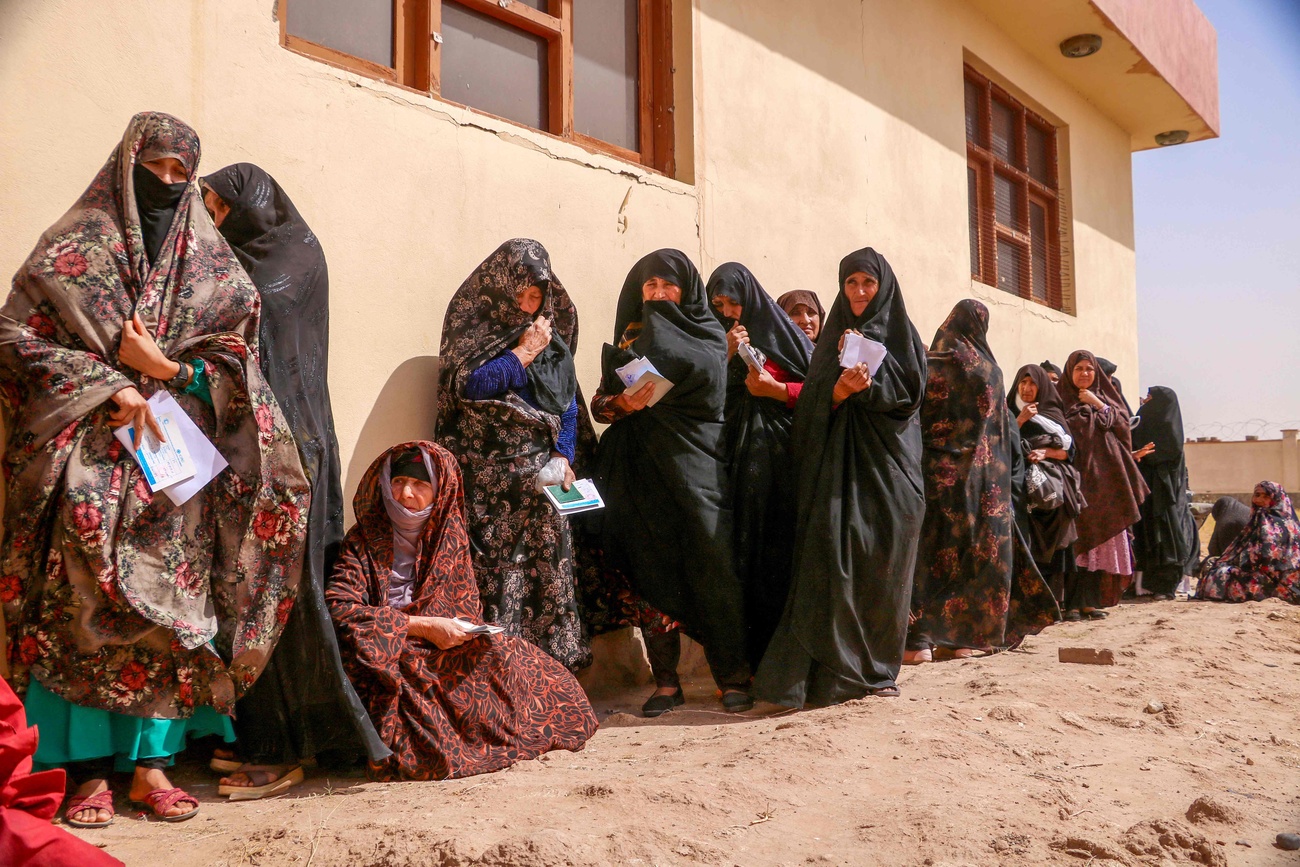 Femme afghane faisant la queue pour recevoir de l'aide