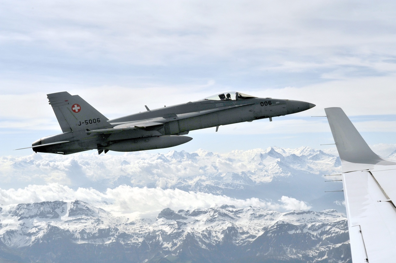 Eine FA18 Hornet fliegt über schneebedeckte berge