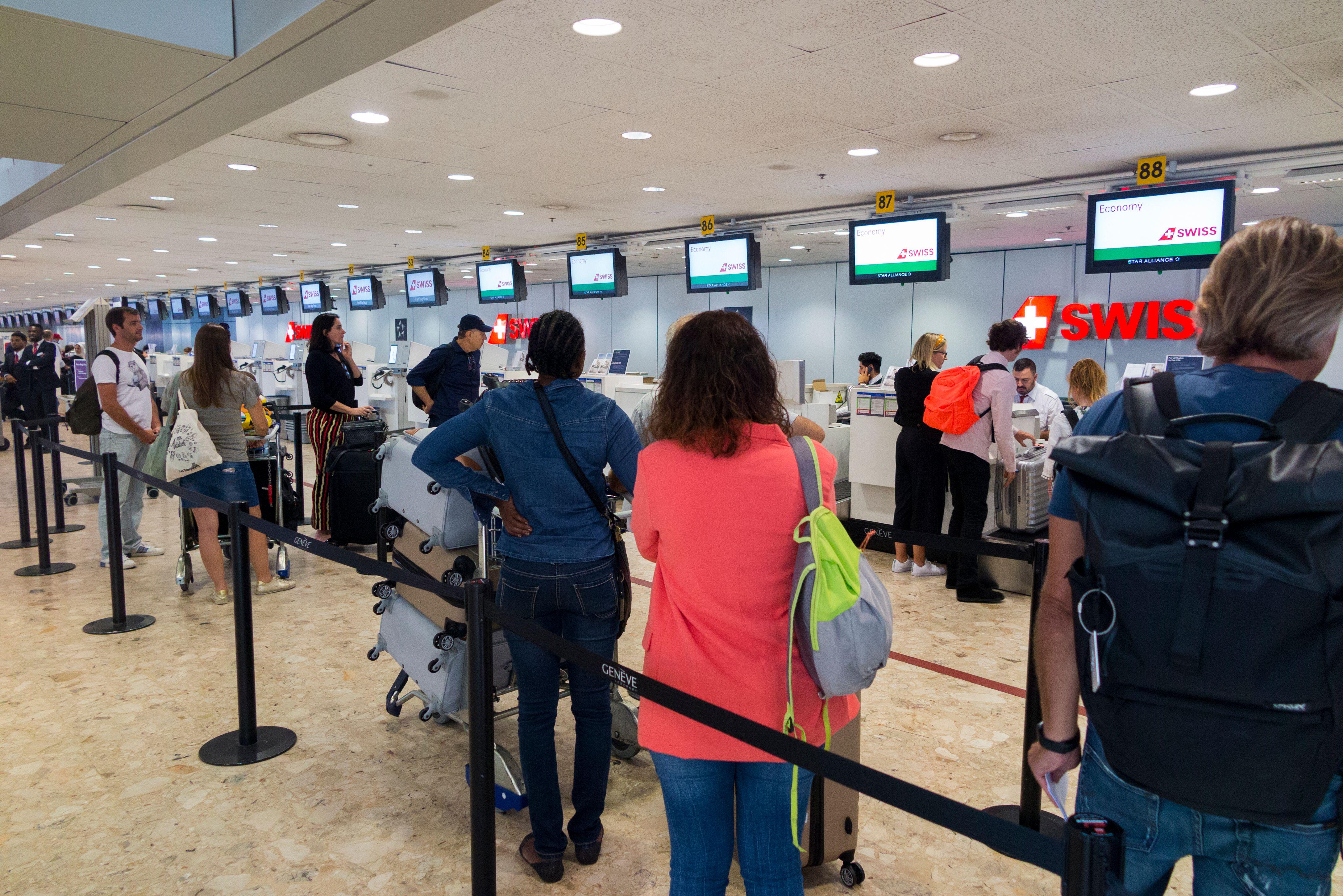Passeggeri svizzeri in coda per il check-in dei bagagli in un aeroporto in Svizzera