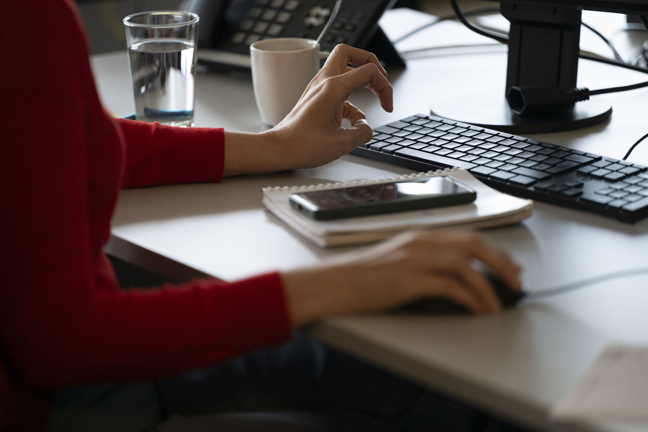Deux mains devant un clavier et une souris d'ordinateur.