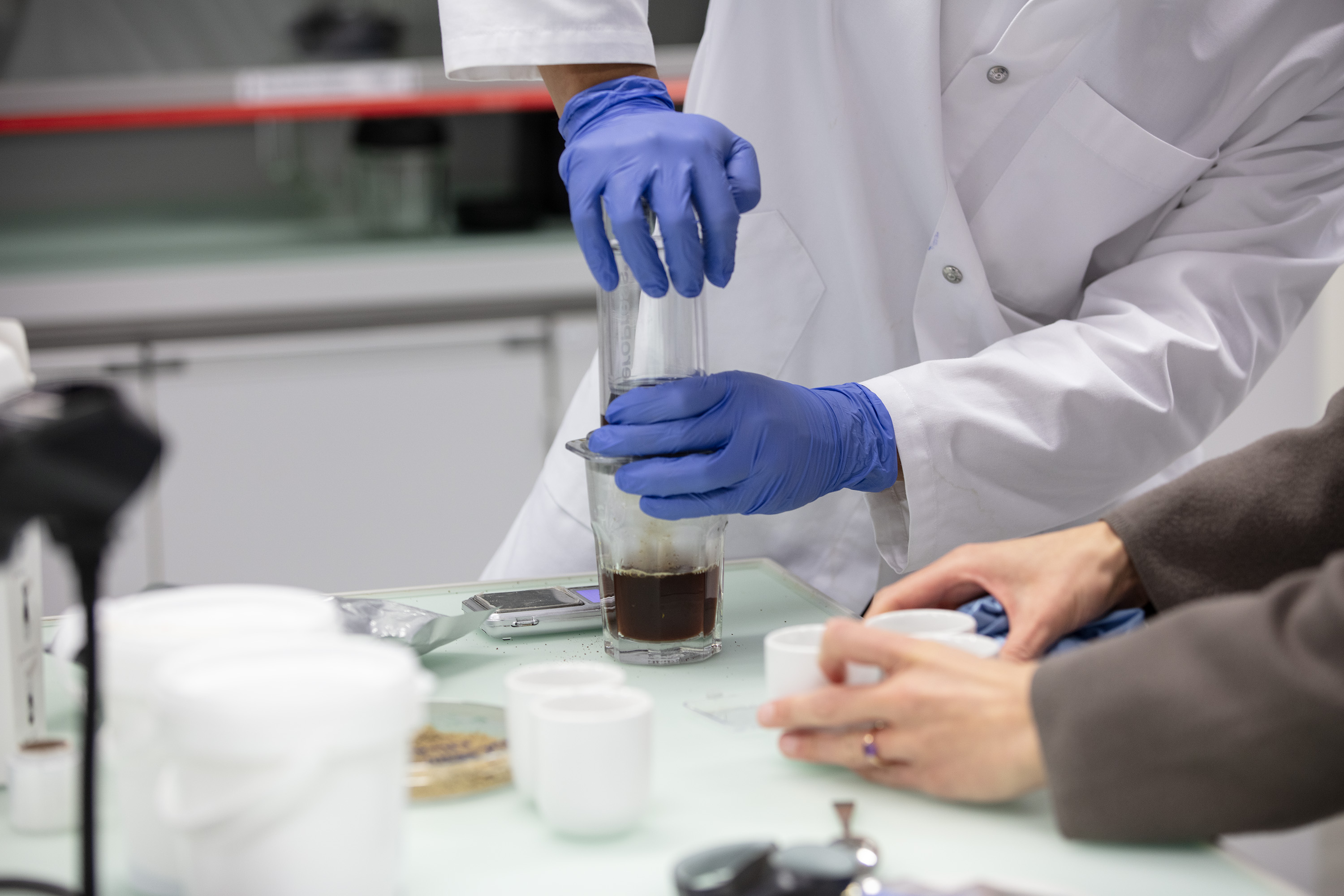 Quatro mãos manipulando objetos em laboratório