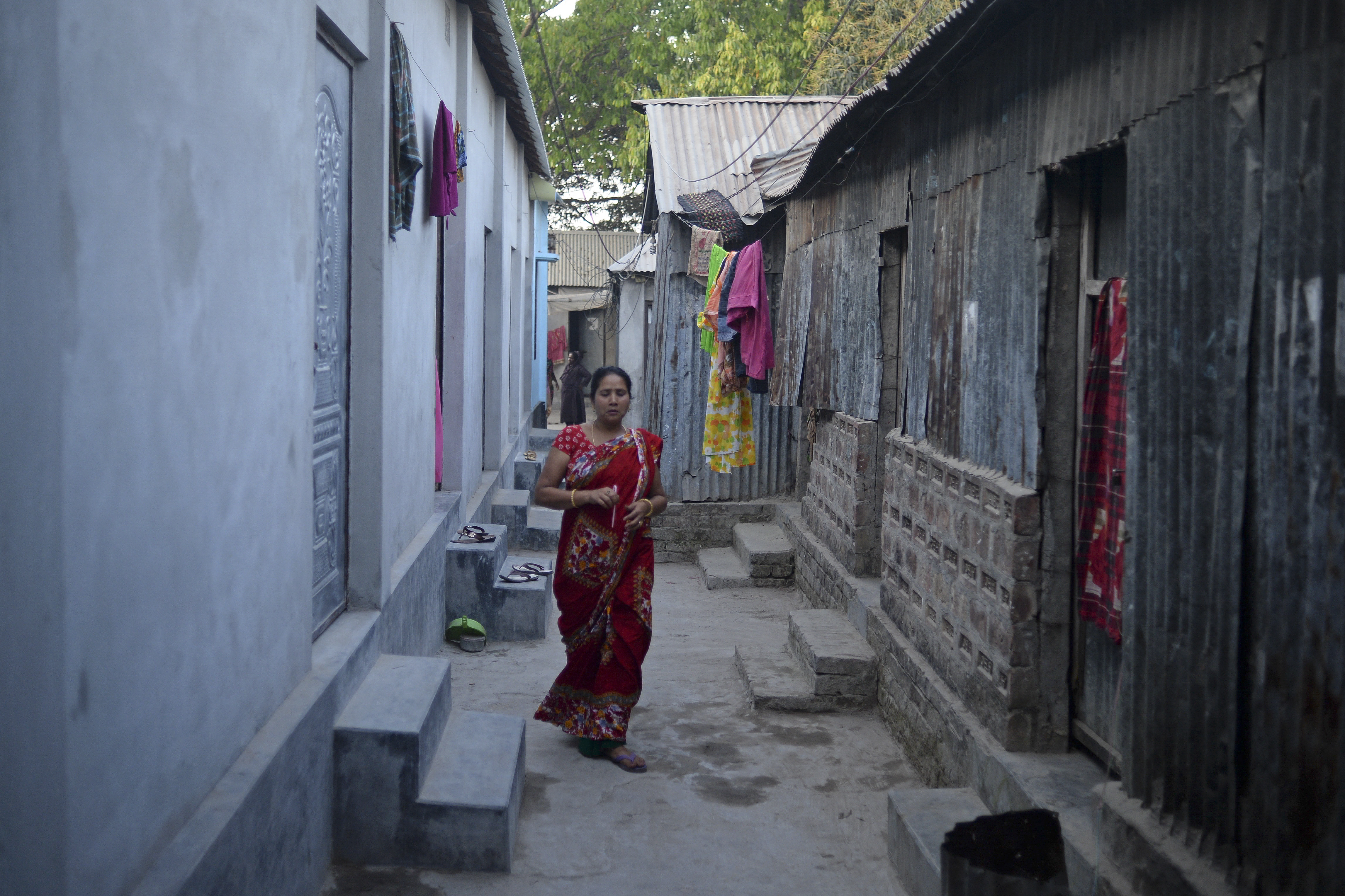 Enge Gasse mit aufgehängter Kleidung und einer gehenden Person.