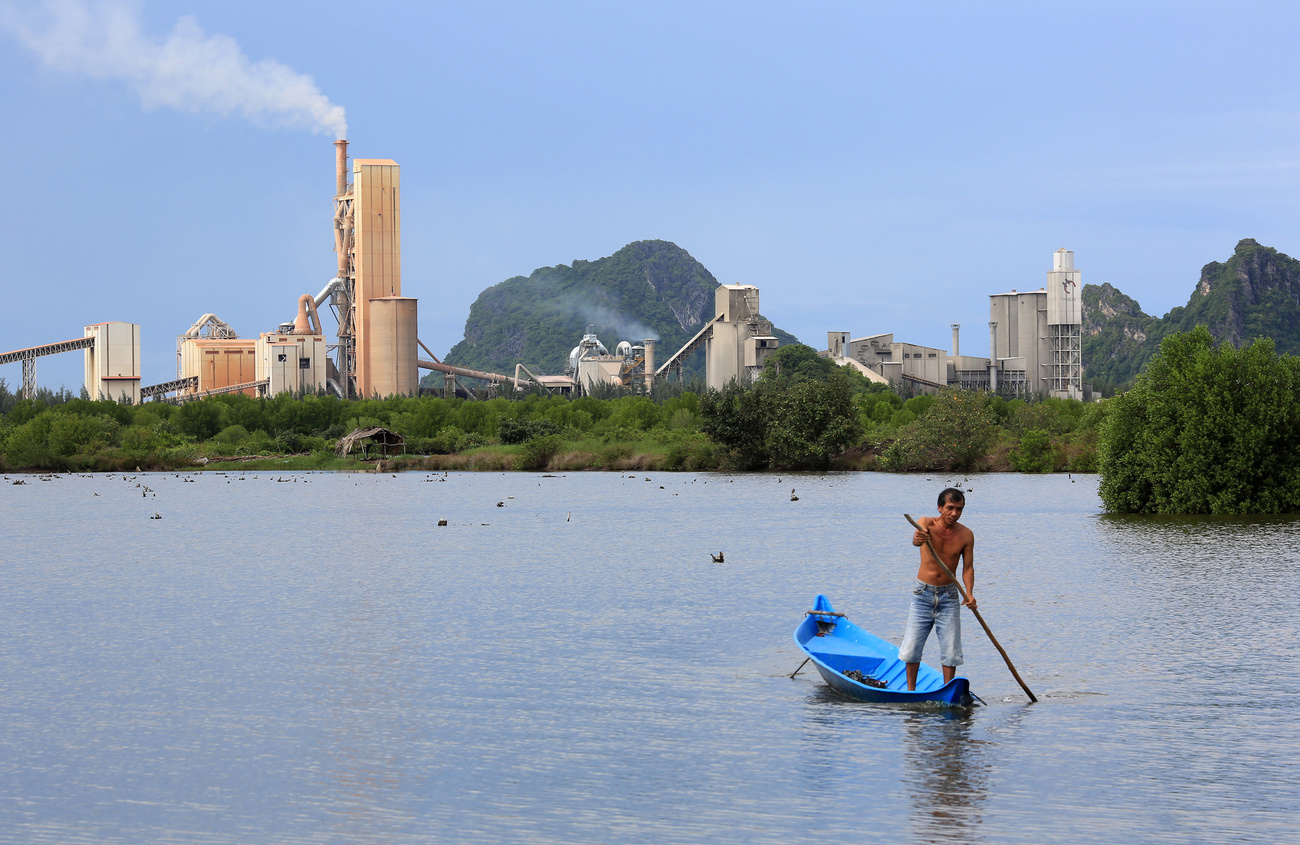 Um pescador em um lago de uma grande cidade