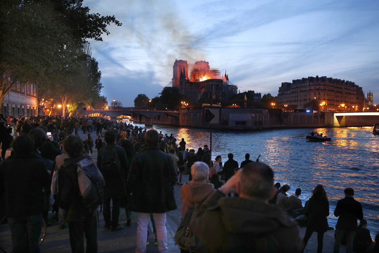 Les Parisiens se rassemblent sur les berges de la Seine pour regarder le triste spectacle.