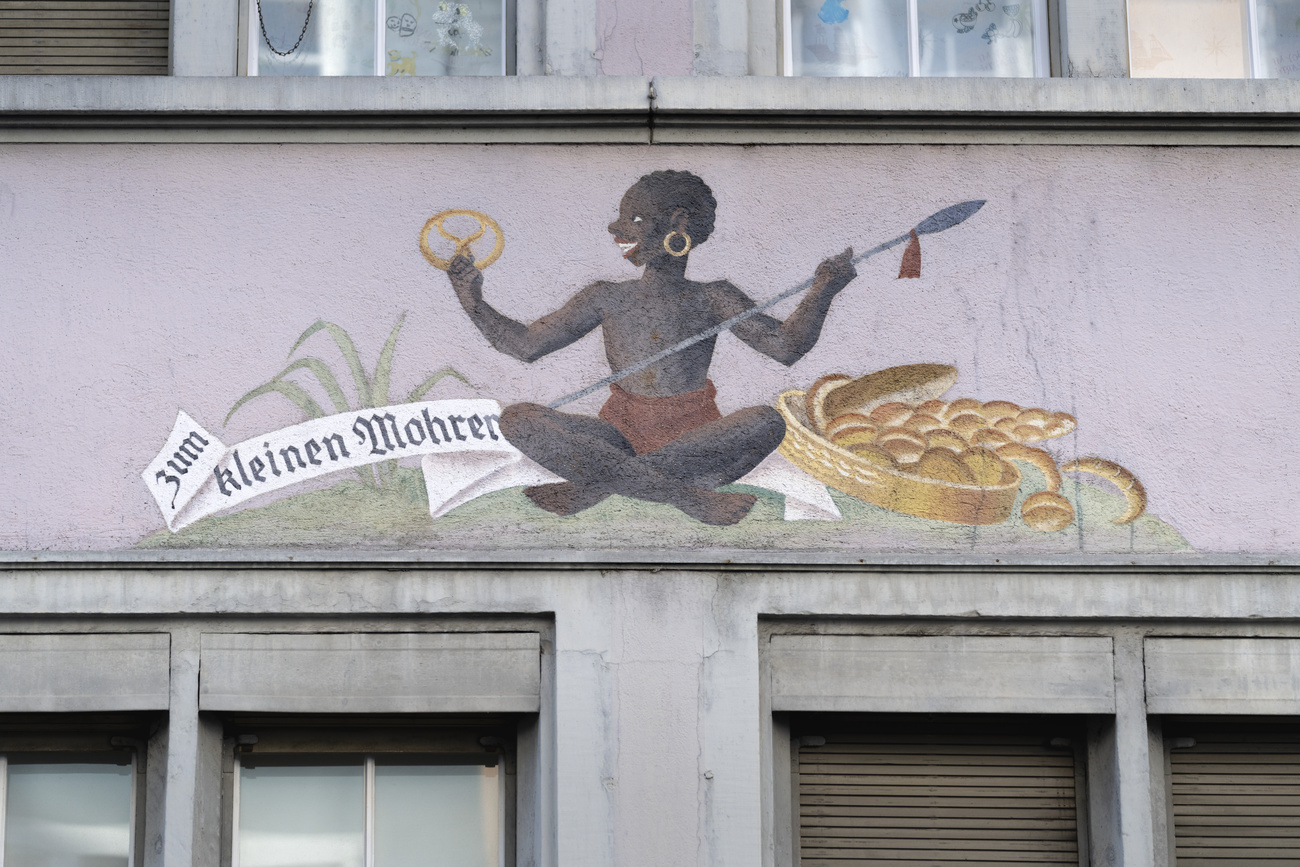 scritta "zum kleinen mohren" e disegno di una persona di colore su un edificio