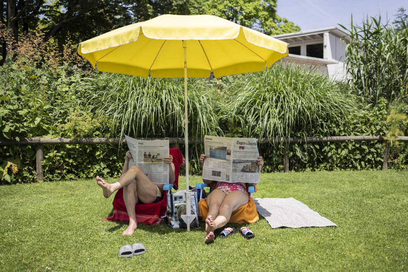 People enjoy the summer weather on Lake Zurich at the Mythenquai lido in Zurich,