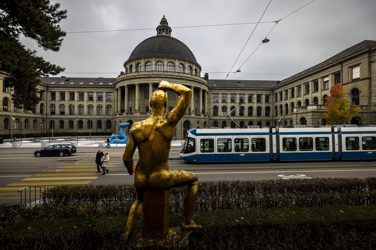 Das Hauptgebäude der ETH Zürich und eine goldene Skulptur