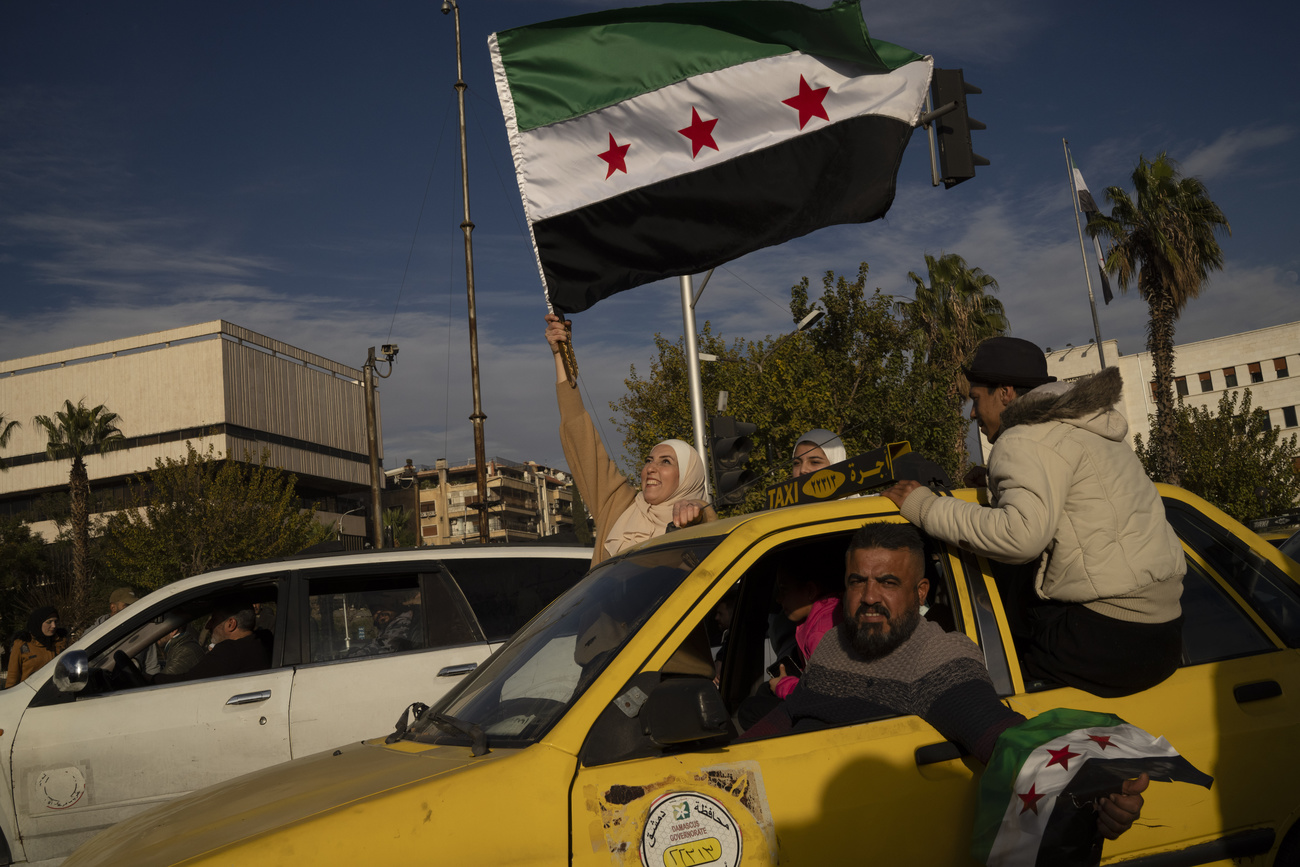 A woman waves a Syrian opposition flag a few days after the fall of Bashar al-Assad's government in Damascus, December 12, 2024.