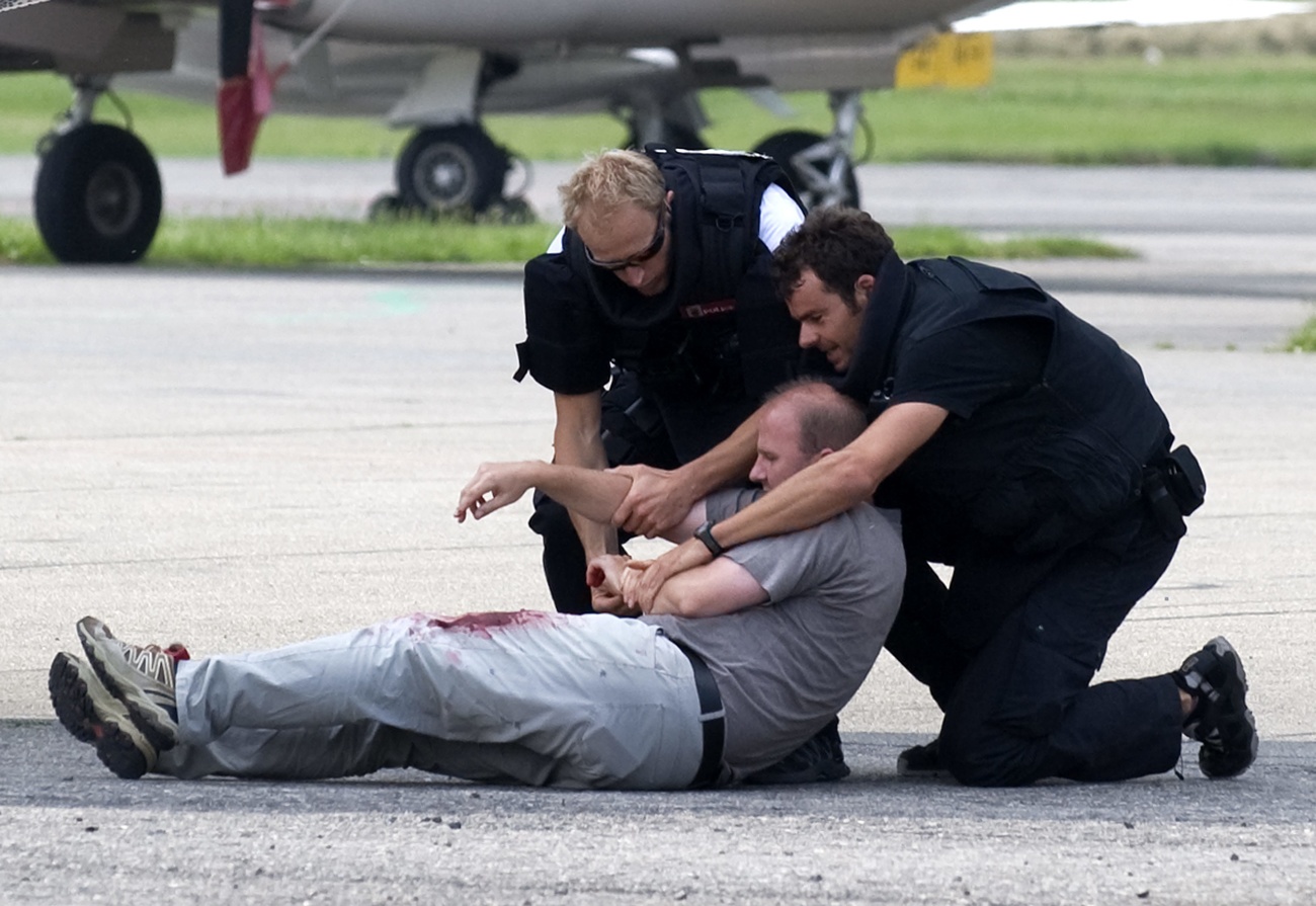 During an emergency exercise on Wednesday, 1 July 2009, two police officers from the Enzian special unit take a hostage who has been shot away from the aircraft to safety. The staff and emergency services of Bern-Belp Airport and the cantonal authorities jointly practise the emergency scenario "Bomb threat and hostage-taking". (KEYSTONE/Marcel Bieri)