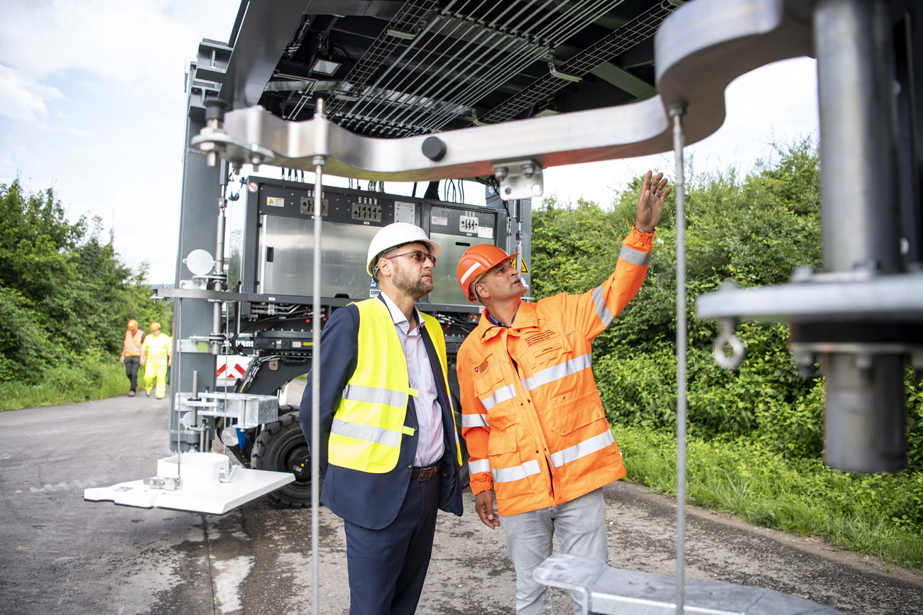 Le chef de projet Jürg Merian (à droite) et Jürg Röthlisberger, directeur de l’Office fédéral des routes, observent le montage du pont de chantier mobile sur un tronçon test.
