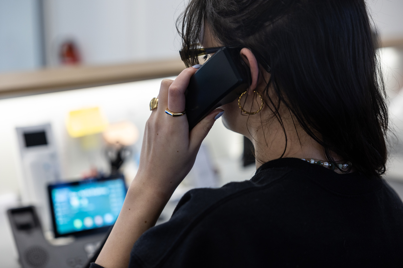 Eine Frau am Telefon, dahinter ein Computerbildschirm