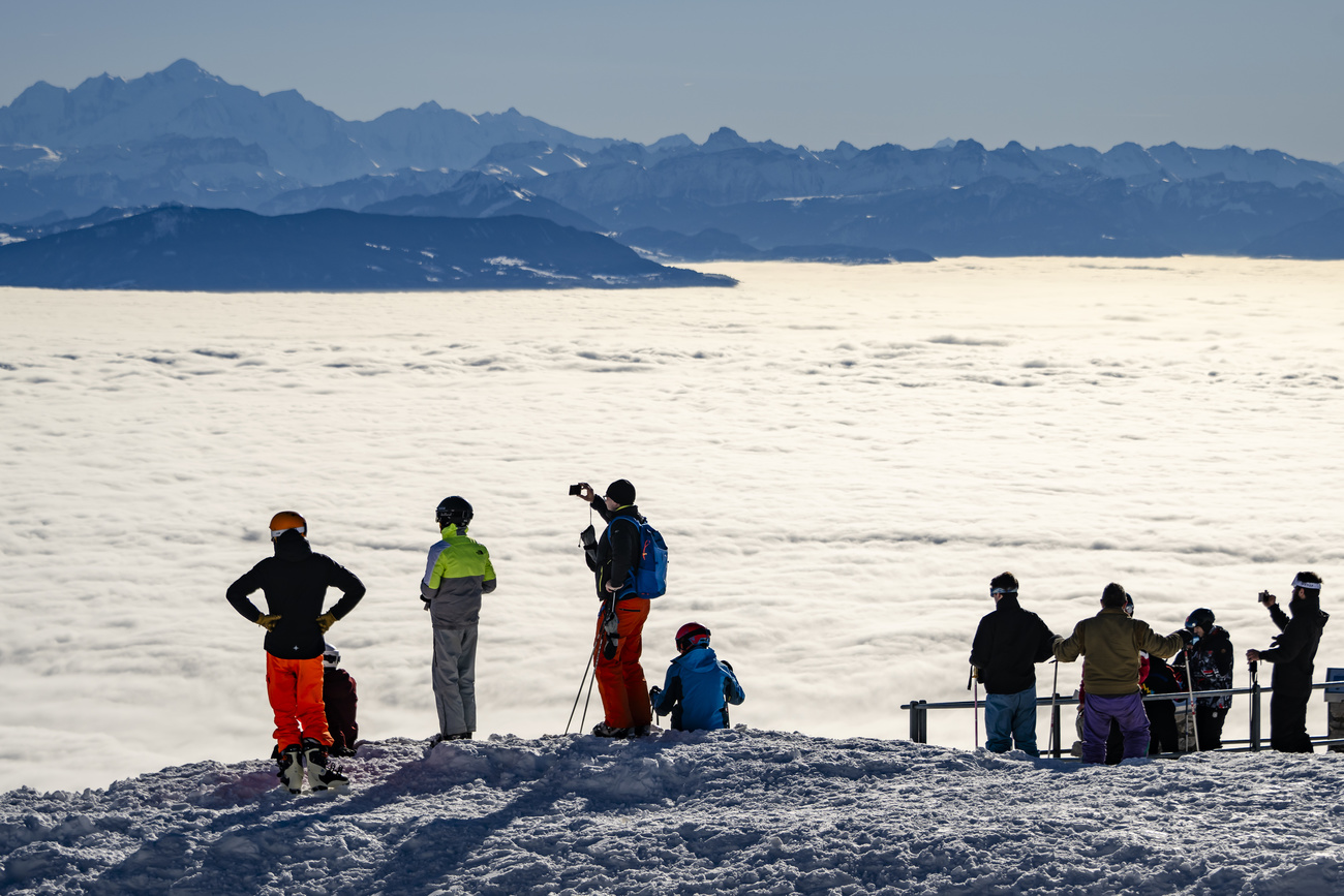 Skiers above the clouds at the La Dole ski area in western Switzerland on December 27, 2024.