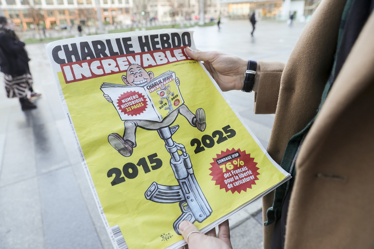 A man holds a copy of the latest issue of the French satirical magazine Charlie Hebdo in Paris, France, 6 January 2024. The French satirical magazine has released a special edition commemorating the tenth anniversary of the shooting that resulted in the deaths of 12 of its employees by the Kouachi brothers on 07 January 2015.