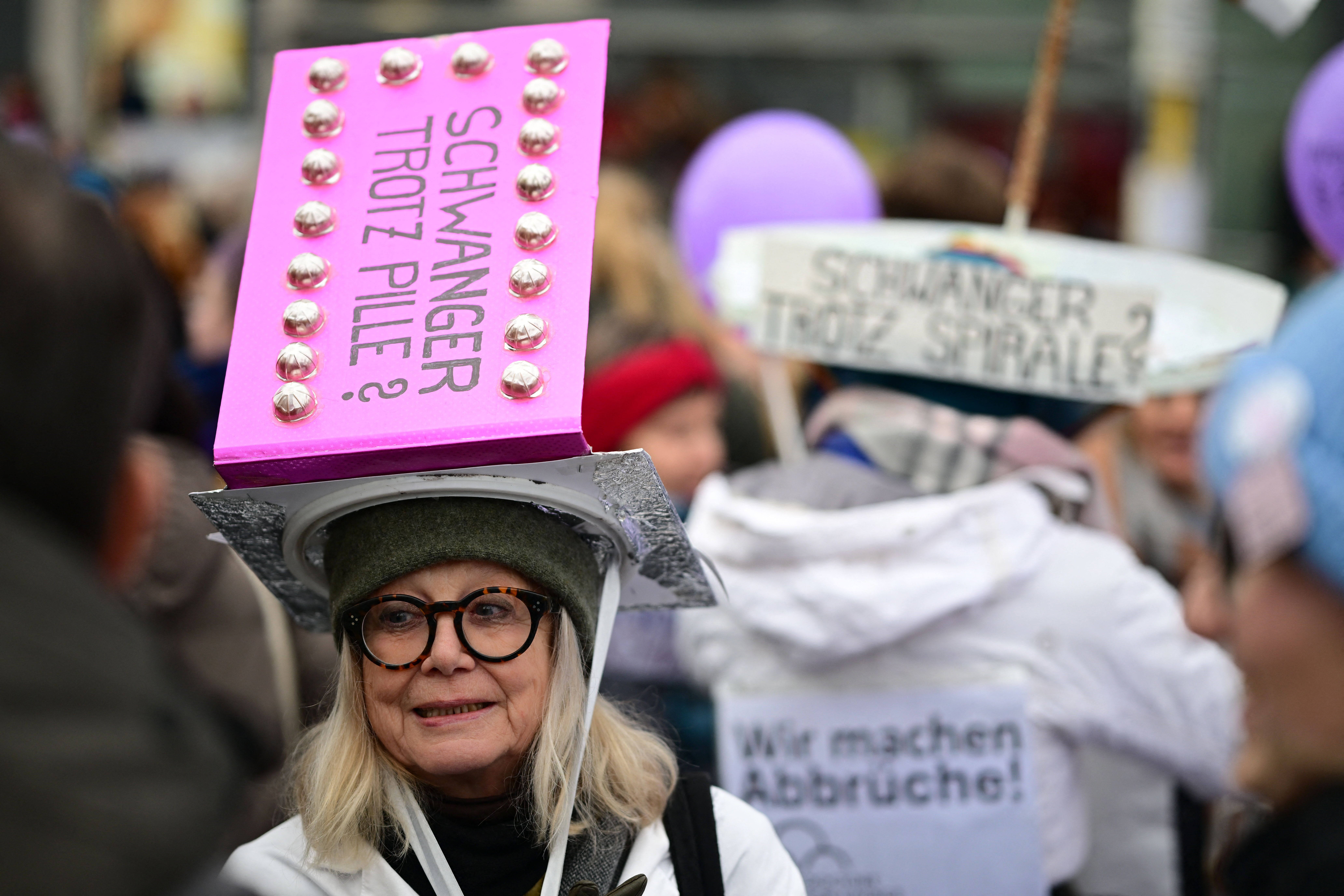 Eine Demonstrantin mit einer Kopfbedeckung mit der Aufschrift „Schwanger trotz Anti-Baby-Pille?“ demonstriert am 7. Dezember 2024 in Berlin für die Legalisierung von Abtreibungen
