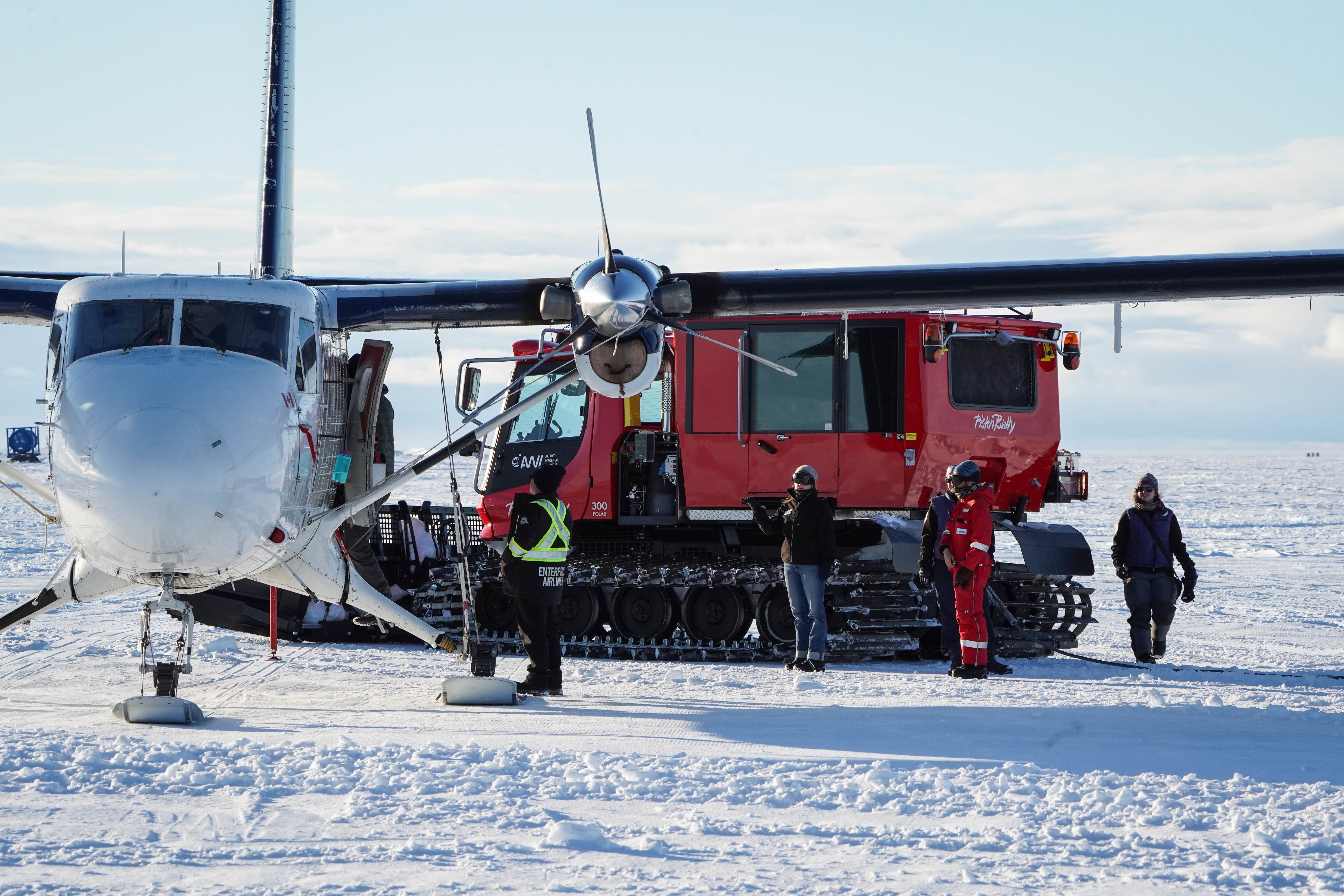 Ein Flugzeug und ein Kettenfahrzeug im Schnee