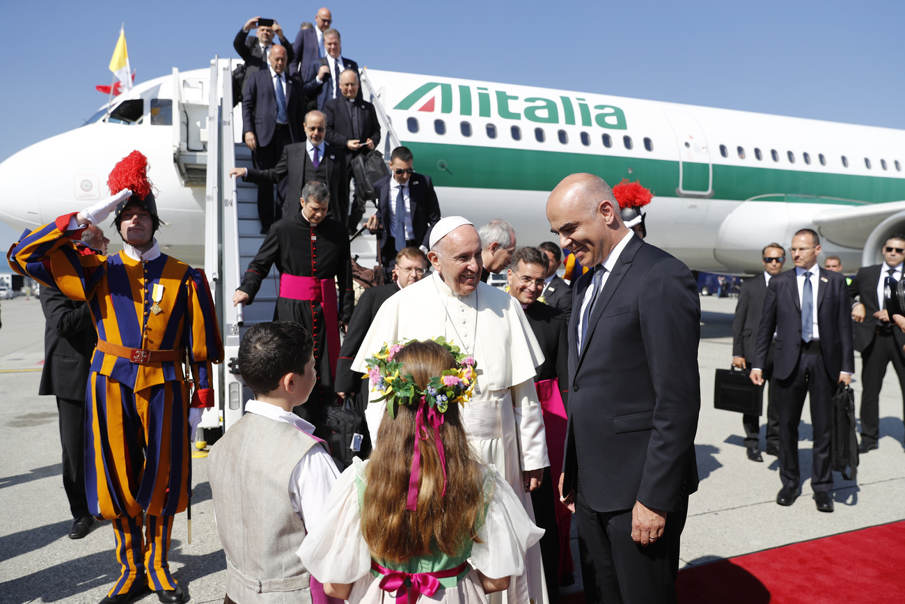 Papst Franziskus wird vom Schweizer Bundespräsidenten Alain Berset begrüsst, nachdem er aus einem Flugzeug mit Anschrift "Alitalia" ausgestiegen ist.