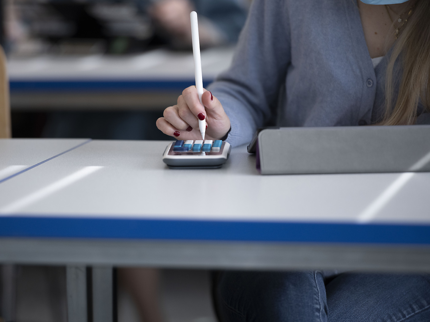 ragazza scrive su calcolatrice con l'aiuto di una penna