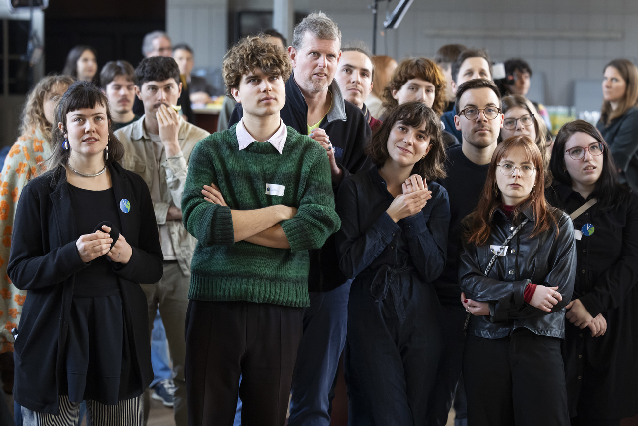 Olivia Senn, Campaignerin Junge Gruene, Linus Dolder, Mitglied Junge Gruene, Magdalena Erni, Co-Praesidentin der Jungen Gruenen, Mirjam Hostetmann, Praesidentin JUSO, vorne von links, reagieren auf die erste Hochrechnung, beim Treffpunkt der Initianten der Umweltverantwortungsinitiative, am Sonntag, 9. Februar 2025, im Progr in Bern. Das Stimmvolk stimmt heute ueber die Umweltverantwortungsinitiative ab. (KEYSTONE/Peter Klaunzer)