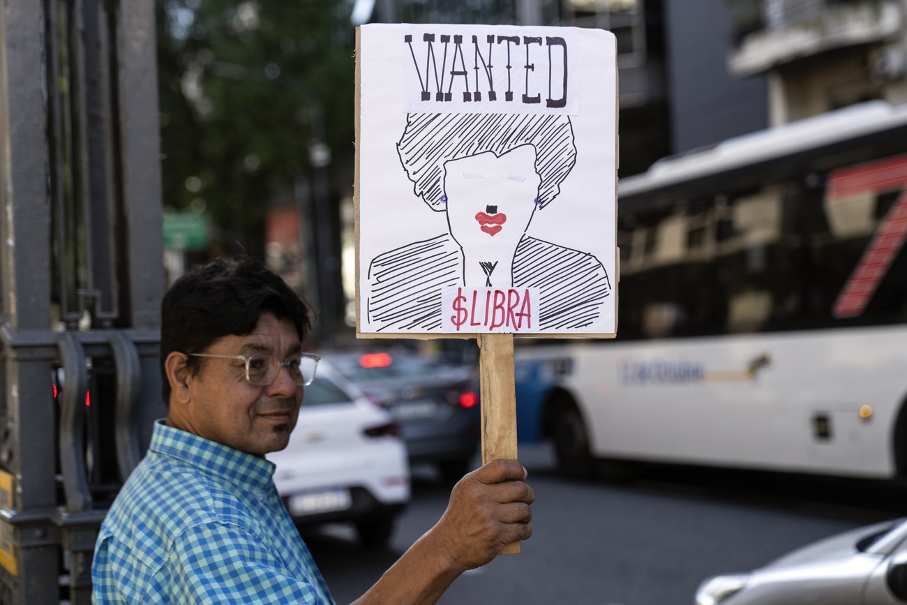 Una persona denuncia con un cartel protesta el caso de la criptomoneda LIBRA.