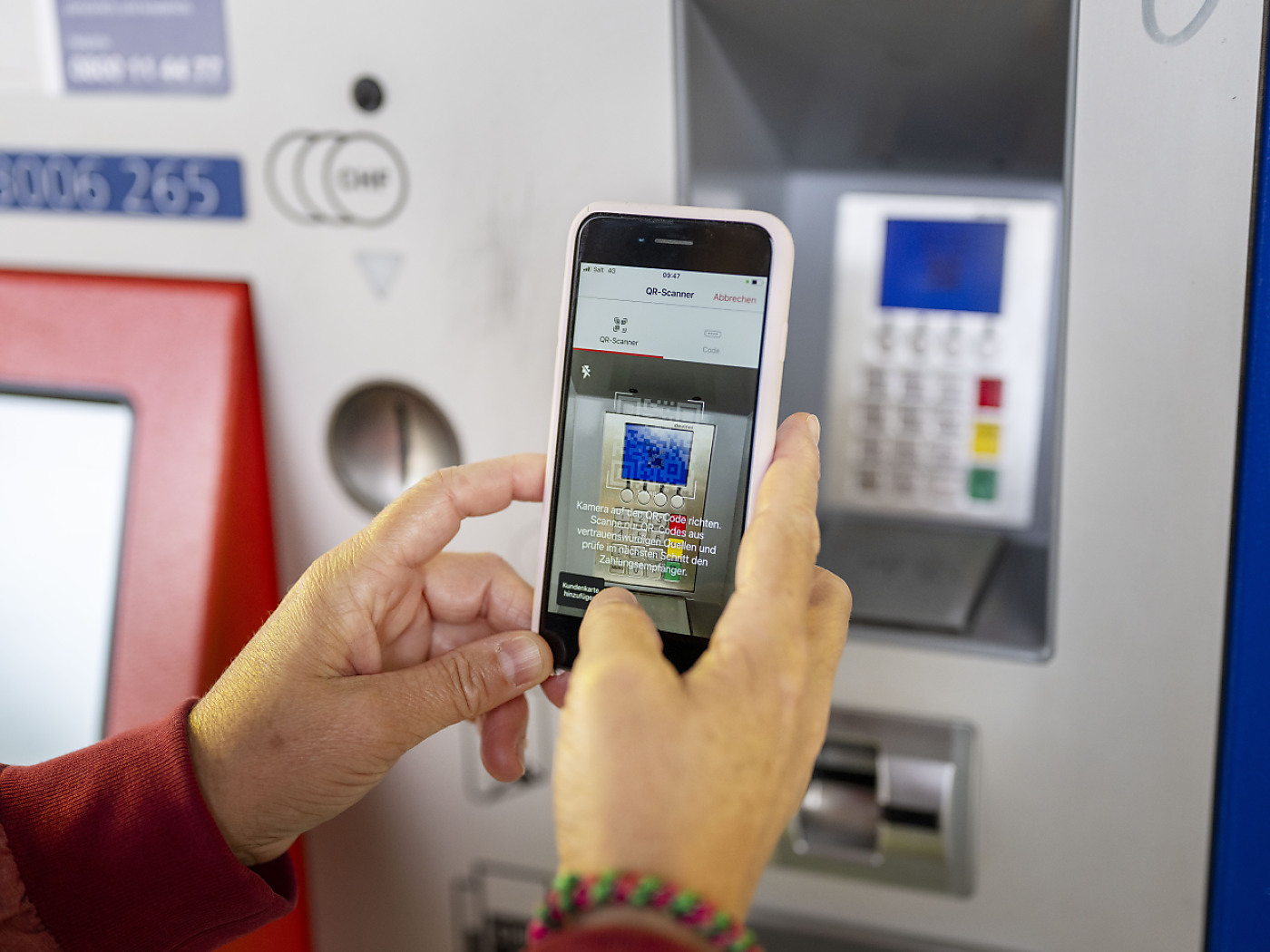 persona paga a una cassa automatica con smartphone