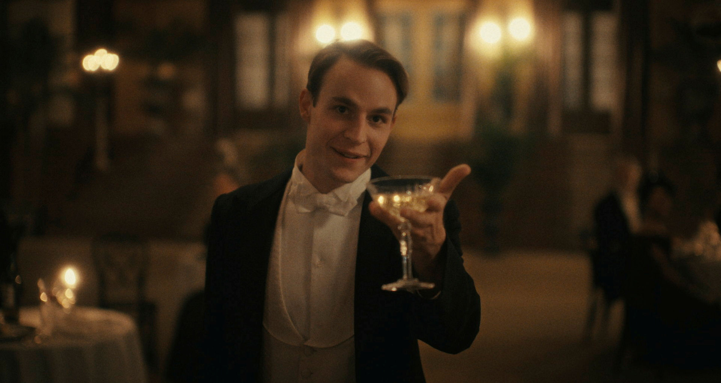 Homem de terno com um copo de vinho na mão