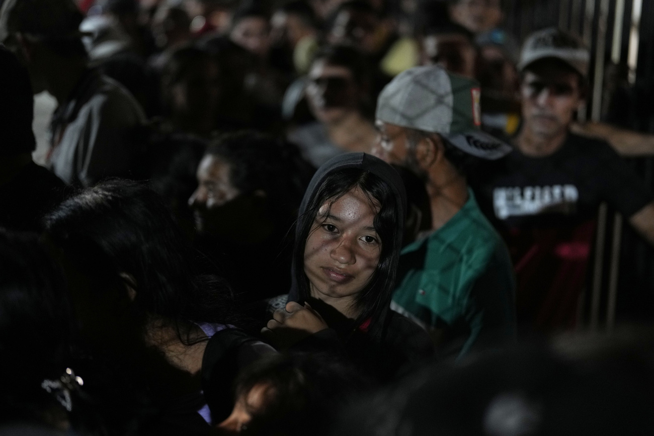 People displaced by violence in towns across the Catatumbo region, where rebels of the National Liberation Army, or ELN, have been clashing with former members of the Revolutionary Armed Forces of Colombia, line up to register for shelter at a soccer stadium in Cúcuta, Colombia, Sunday, Jan. 19, 2025. (AP Photo/Fernando Vergara)