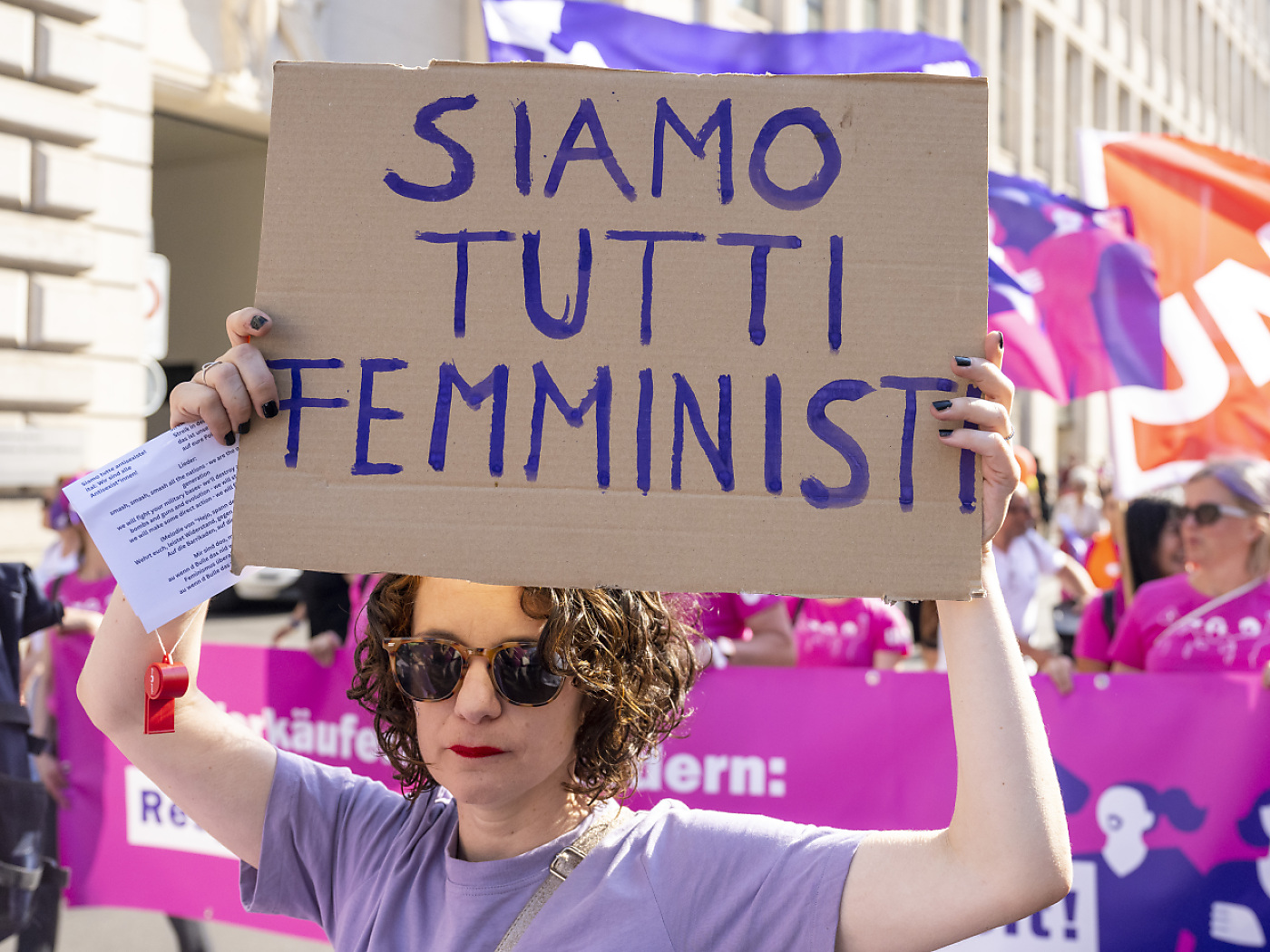 Donna regge cartello con scritta SIAMO TUTTI FEMMINISTI