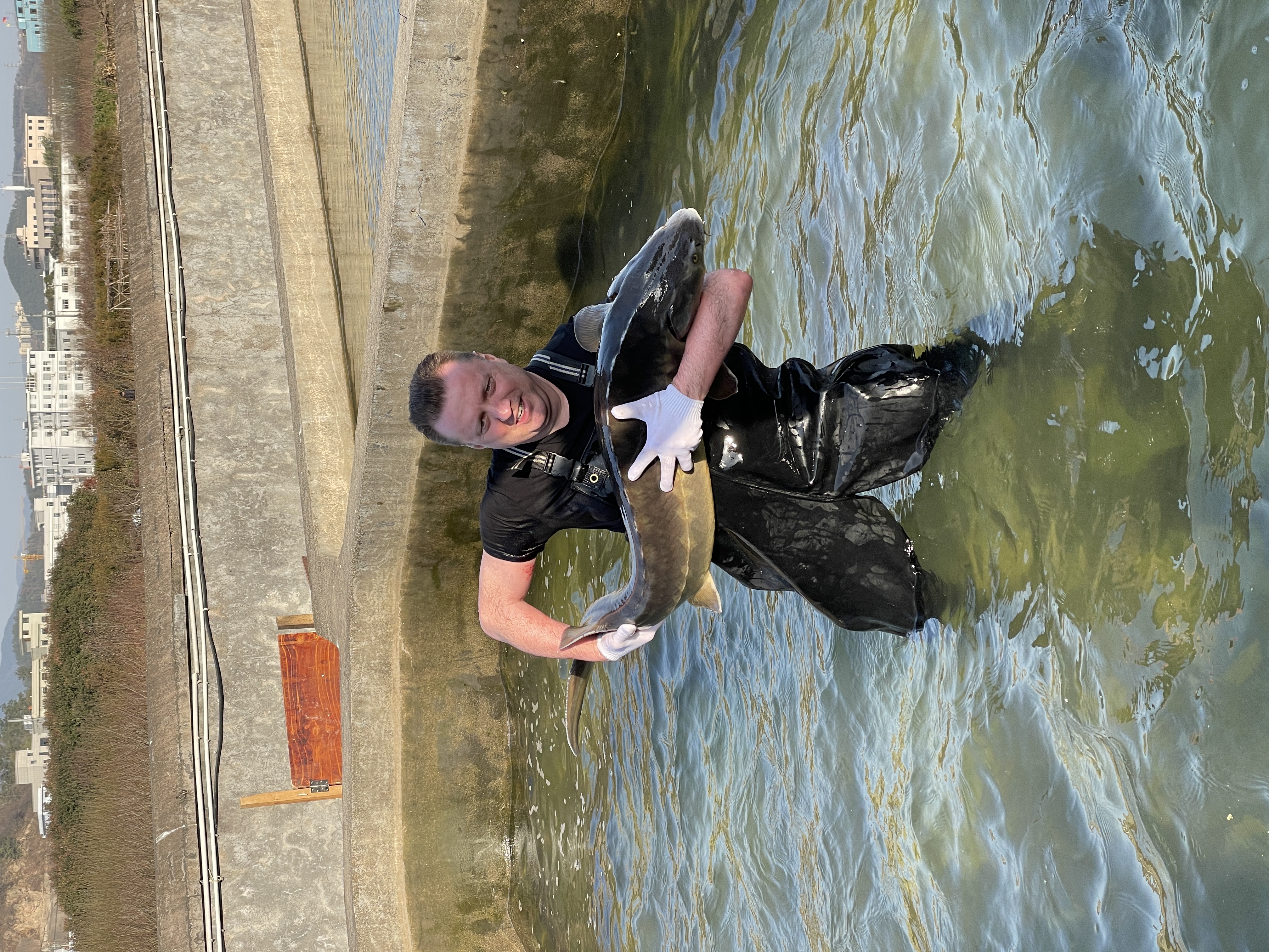 Carlo Schmed and a sturgeon on a caviar farm in China.