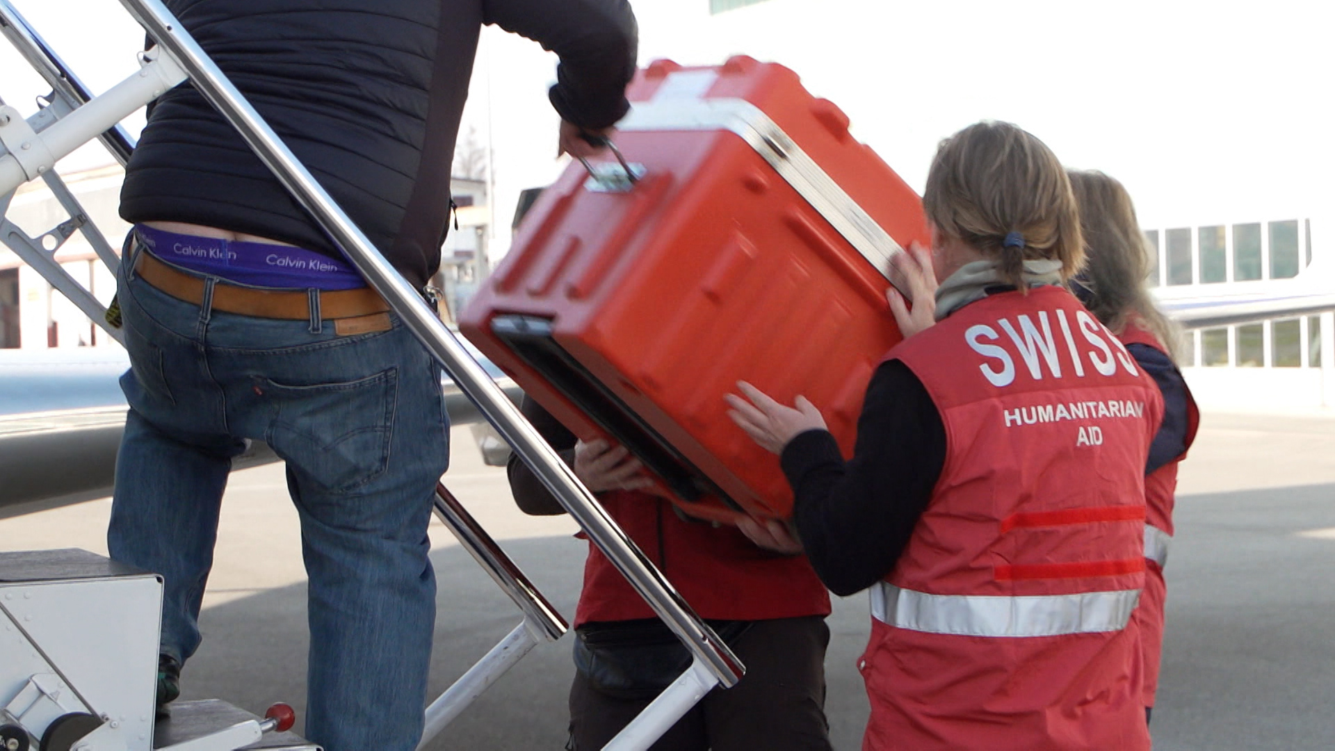 Menschen packen eine Kiste in ein Flugzeug