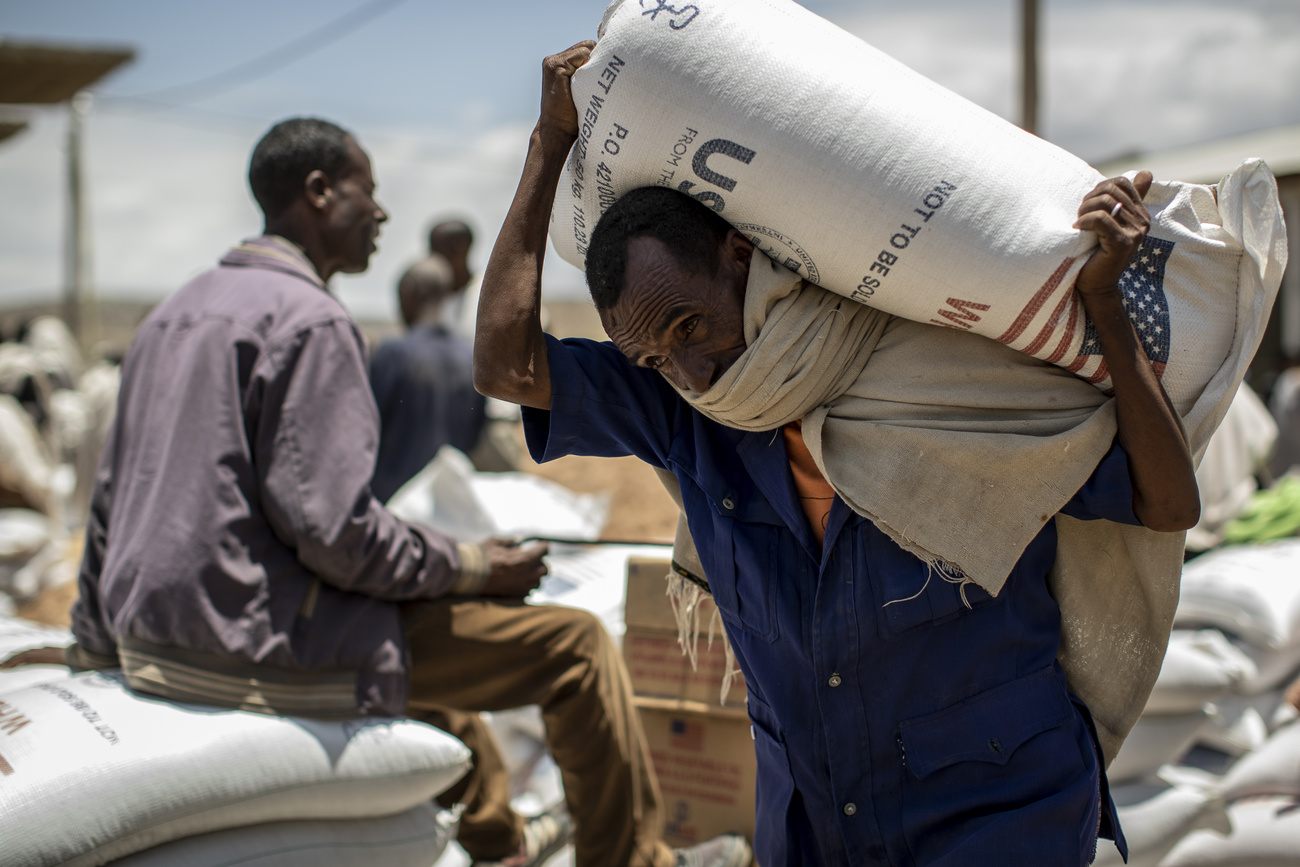 Un homme porte un sac distribué par l'USAID.