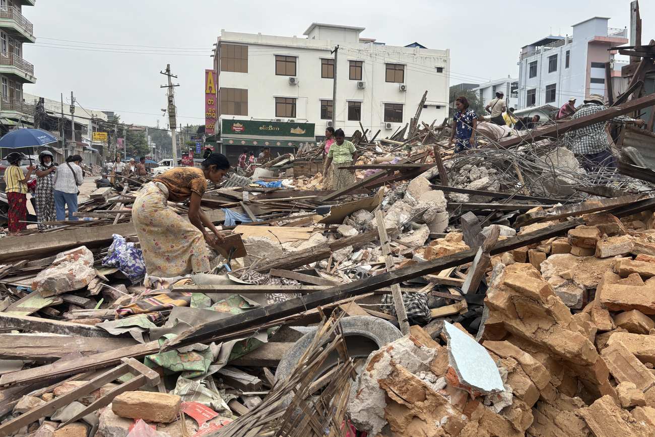 People clear the rubble of damaged buildings after the earthquake in Naypyitaw, Myanmar, on 28 March.