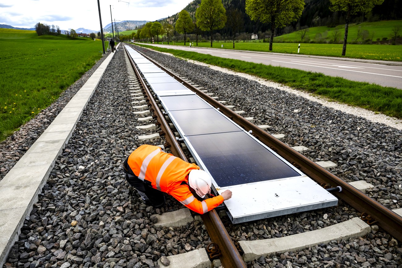 un operaio ferroviario verifica dei pannelli solari installati tra i binari