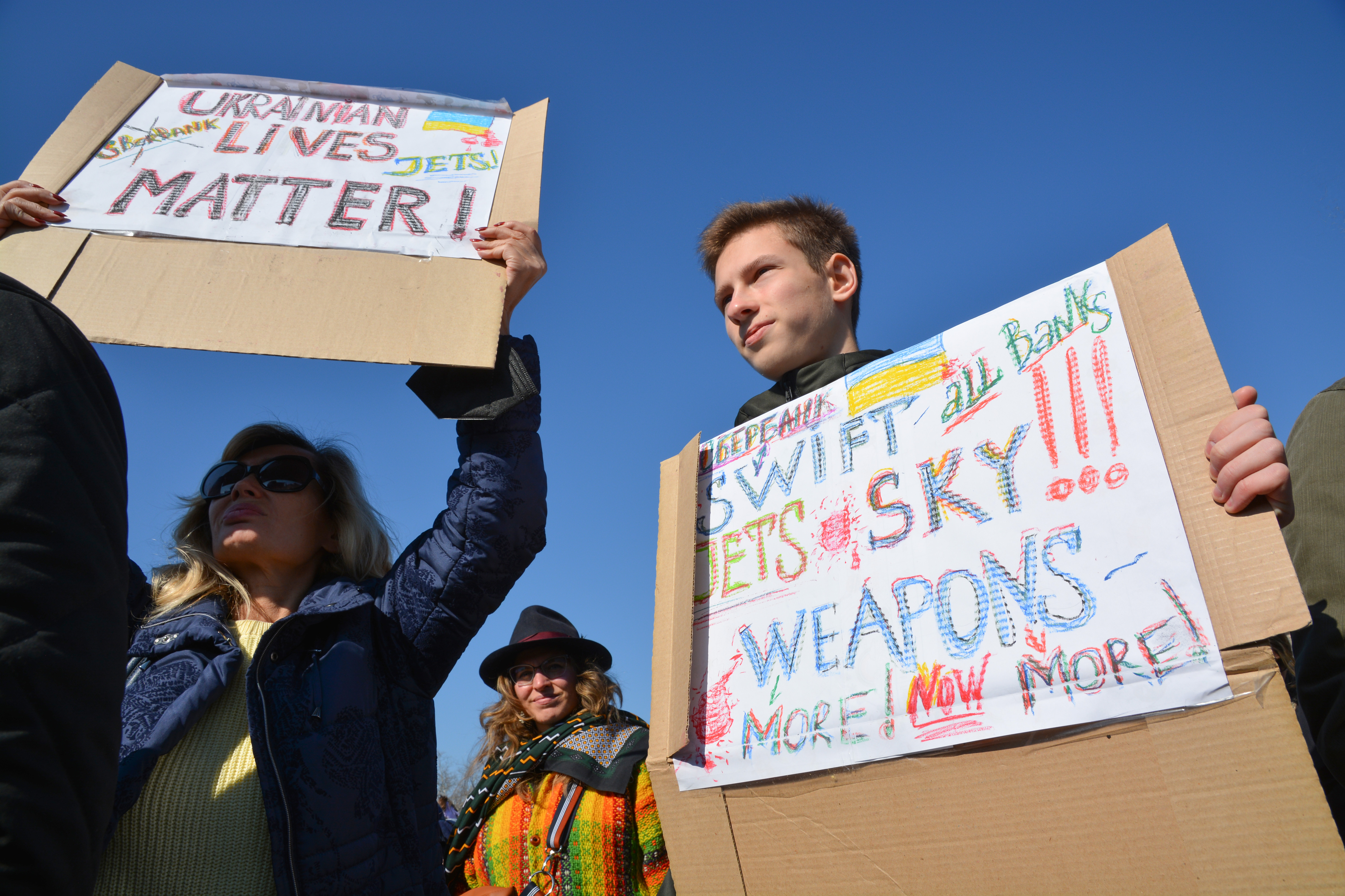 Menschen demonstrieren mit Schildern gegen den Krieg