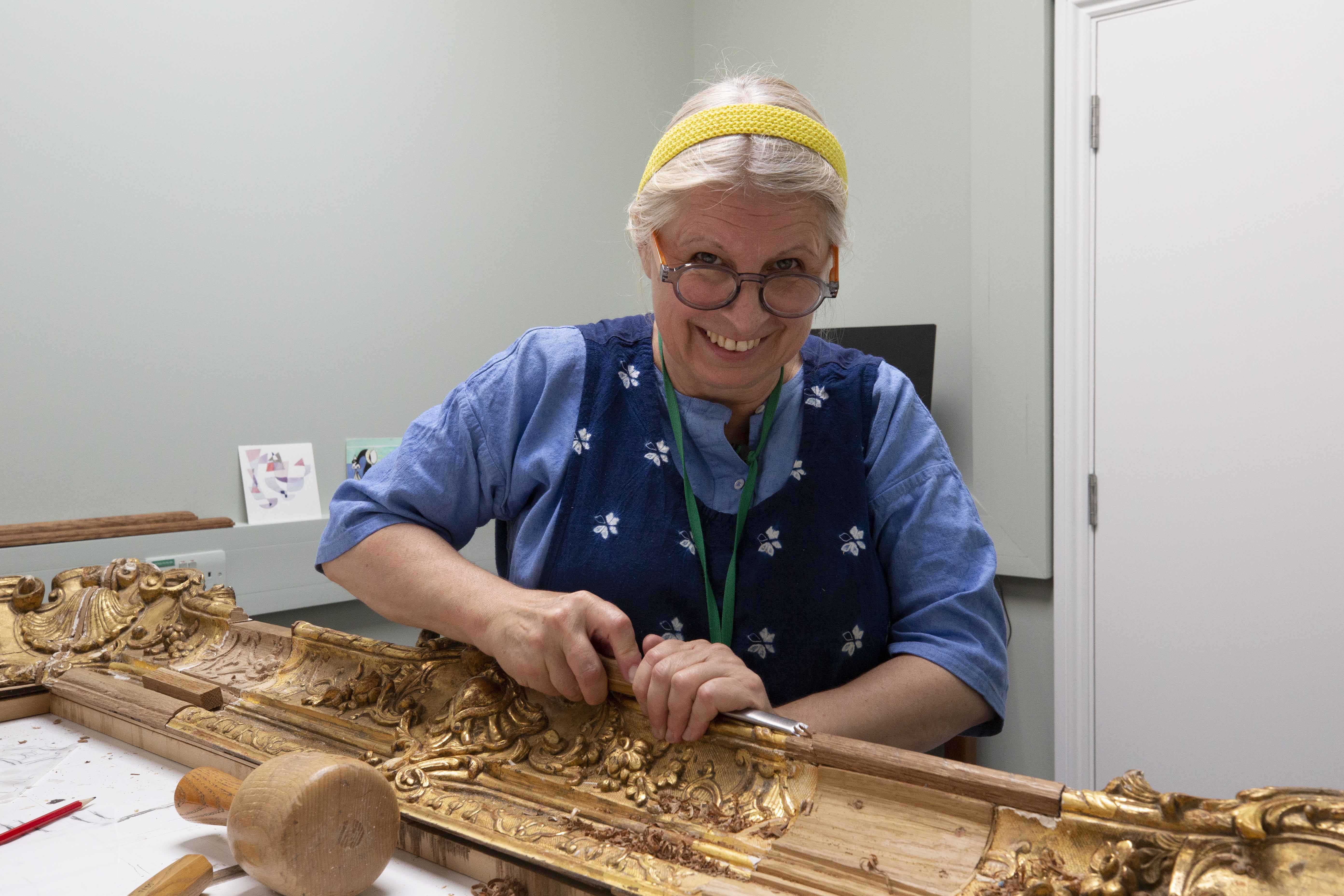 Eine Frau vergoldet einen Bilderrahmen