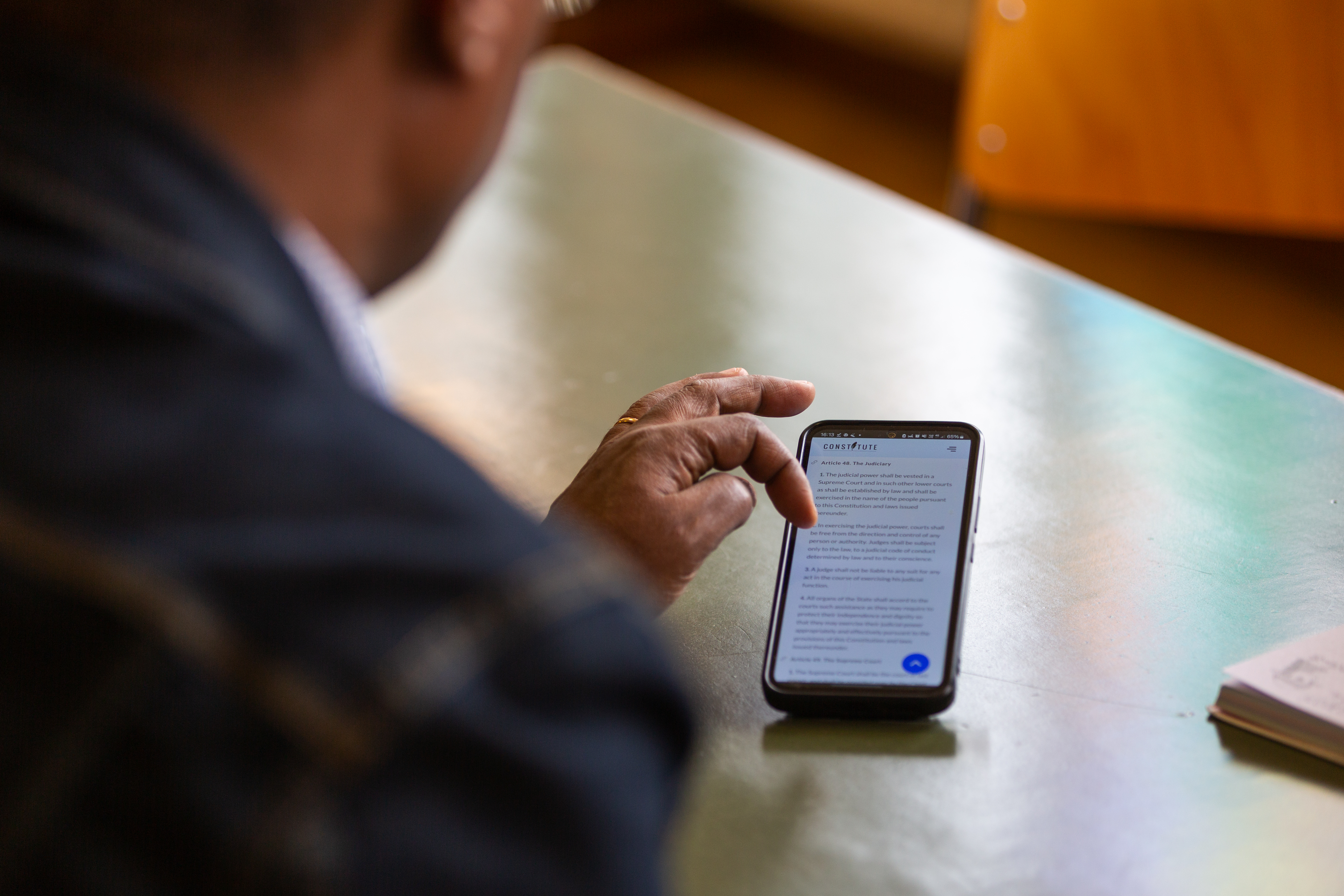 un uomo scrolla col dito sullo schermo di uno smartphone