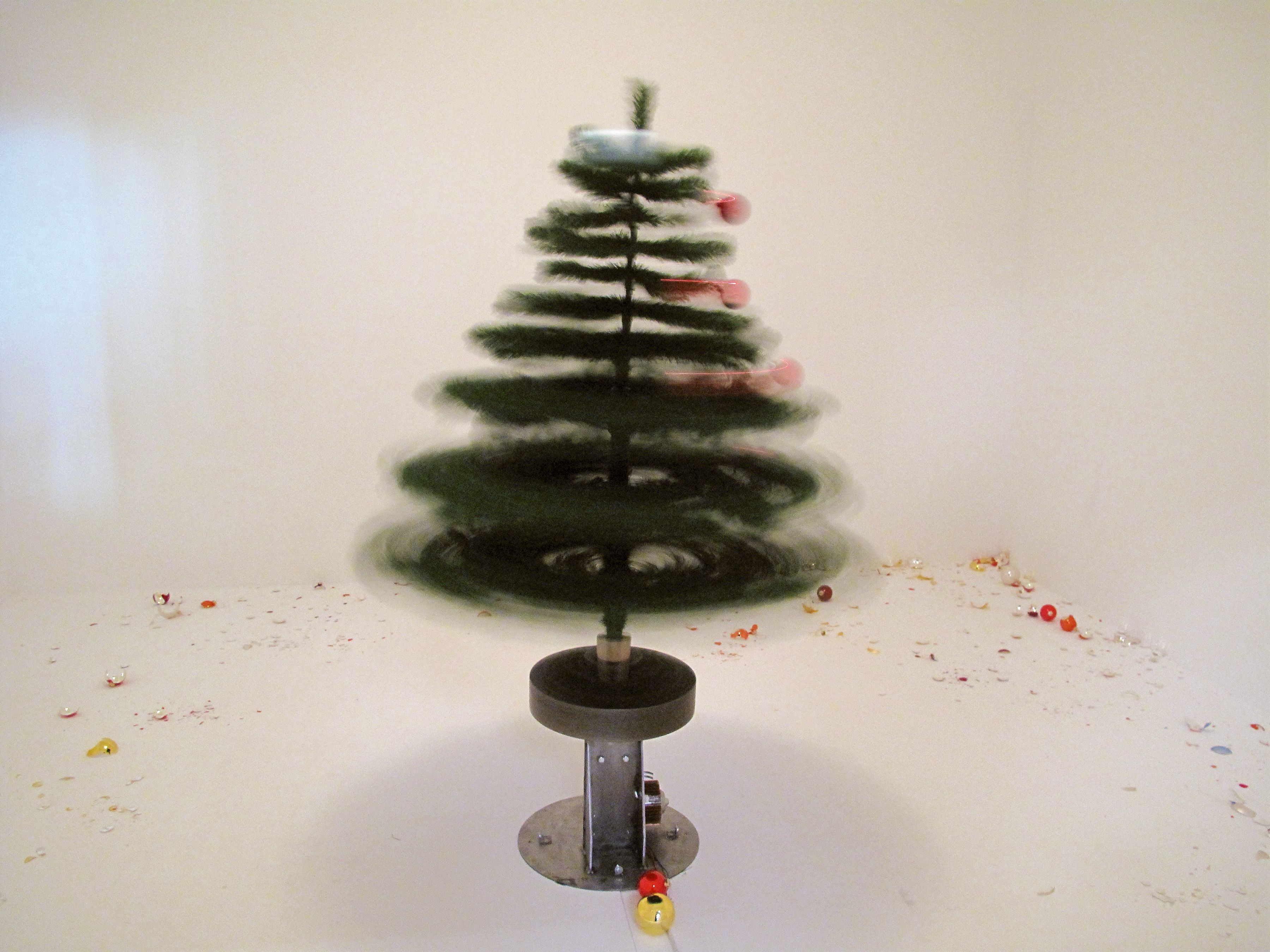 The Christmas tree and its shattered baubles remain behind glass for the safety of the audience.