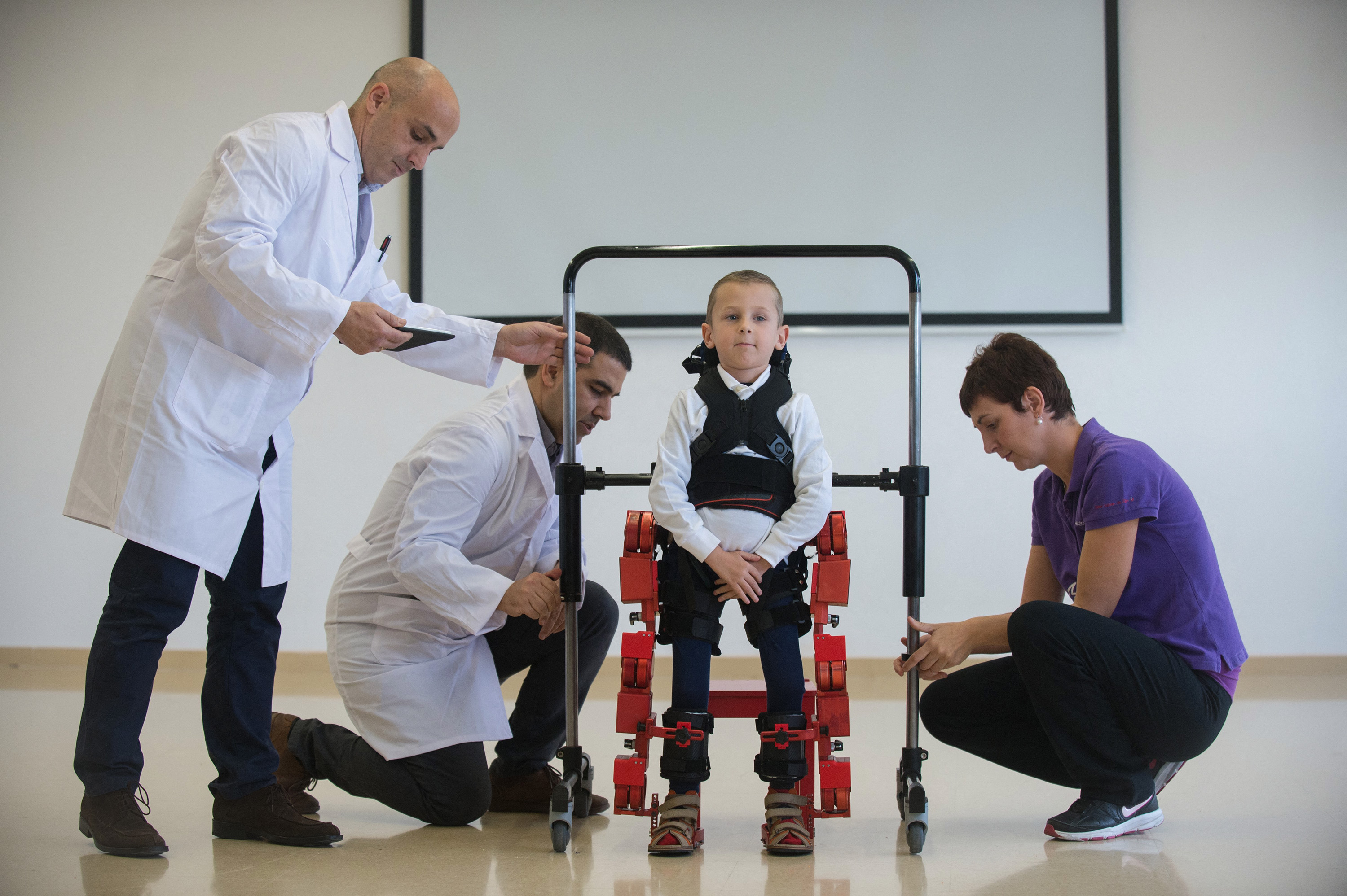 A young patient is fitted with an exoskeleton.