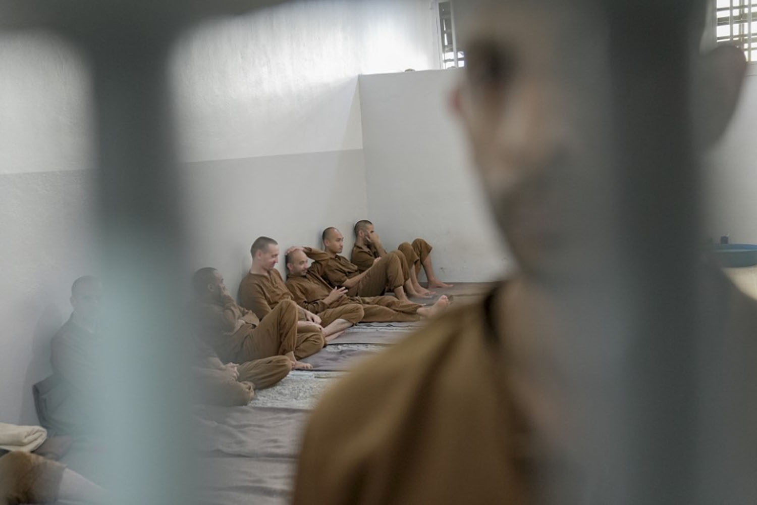 A prisoner sits inside a crowded cell in the IS prison in Al-Hasaka, Syria.
