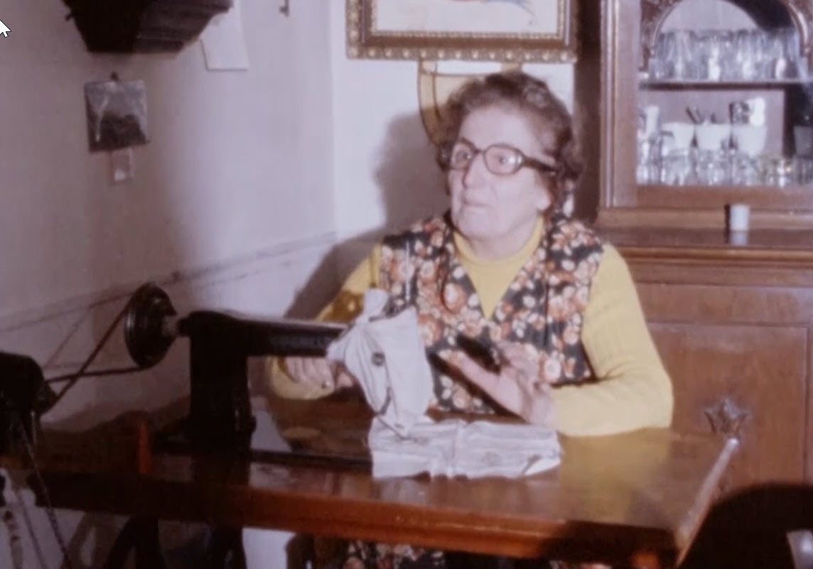 Signora seduta dietro ad una macchina da cucire