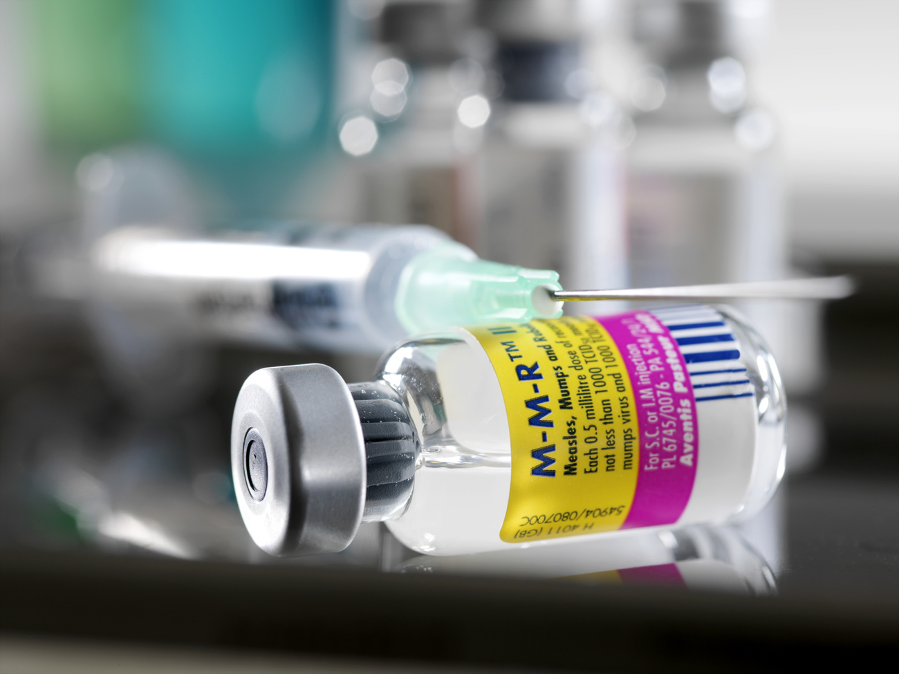 MMR vaccine. Syringe and vial on a counter. This combined vaccine protects infants from three viral diseases: measles, mumps and rubella.