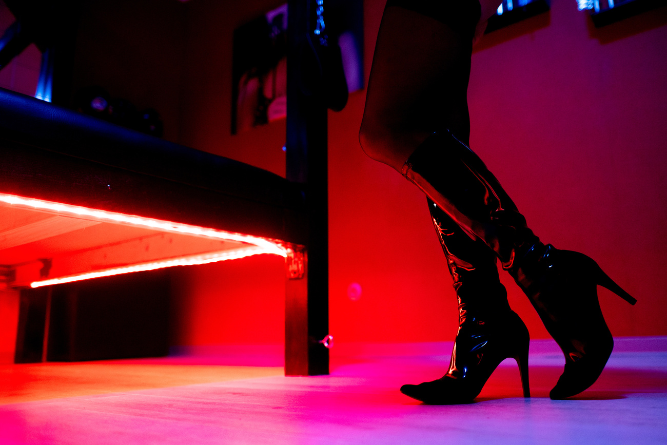 Gambe di donna in un locale a luci rosse.