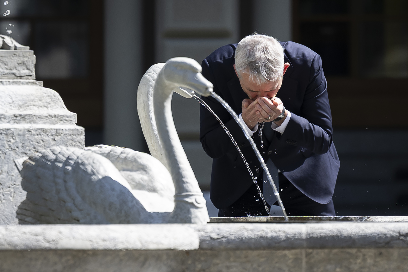 Le conseiller fédéral Beat Jans boit de l'eau de la fontaine de Dame Berna, avant une conférence de presse sur la mise en œuvre de la clause de sauvegarde à l'accord sur la libre circulation des personnes, le mercredi 14 mai 2025, à Berne.