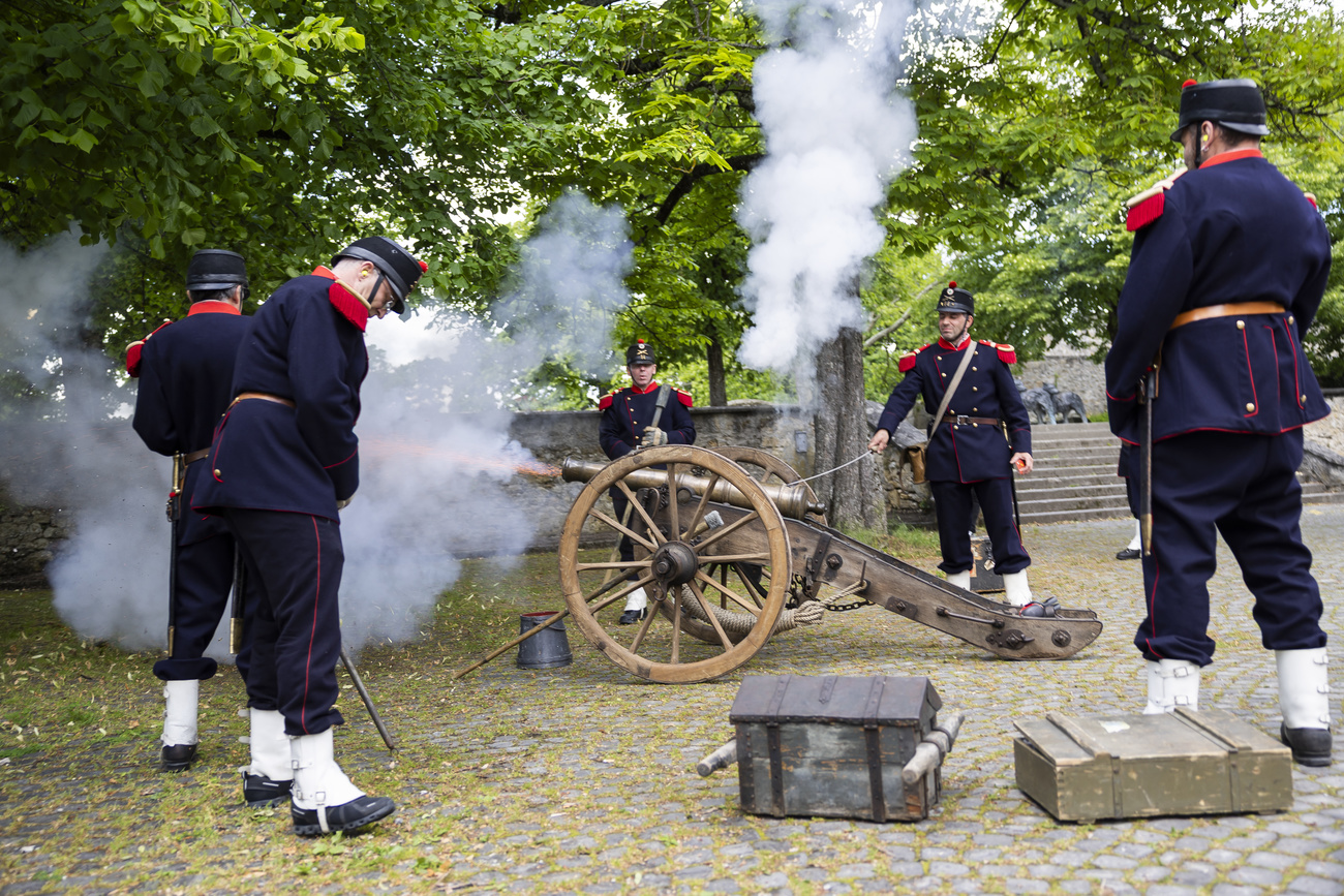 persone in antica uniforme con cannone
