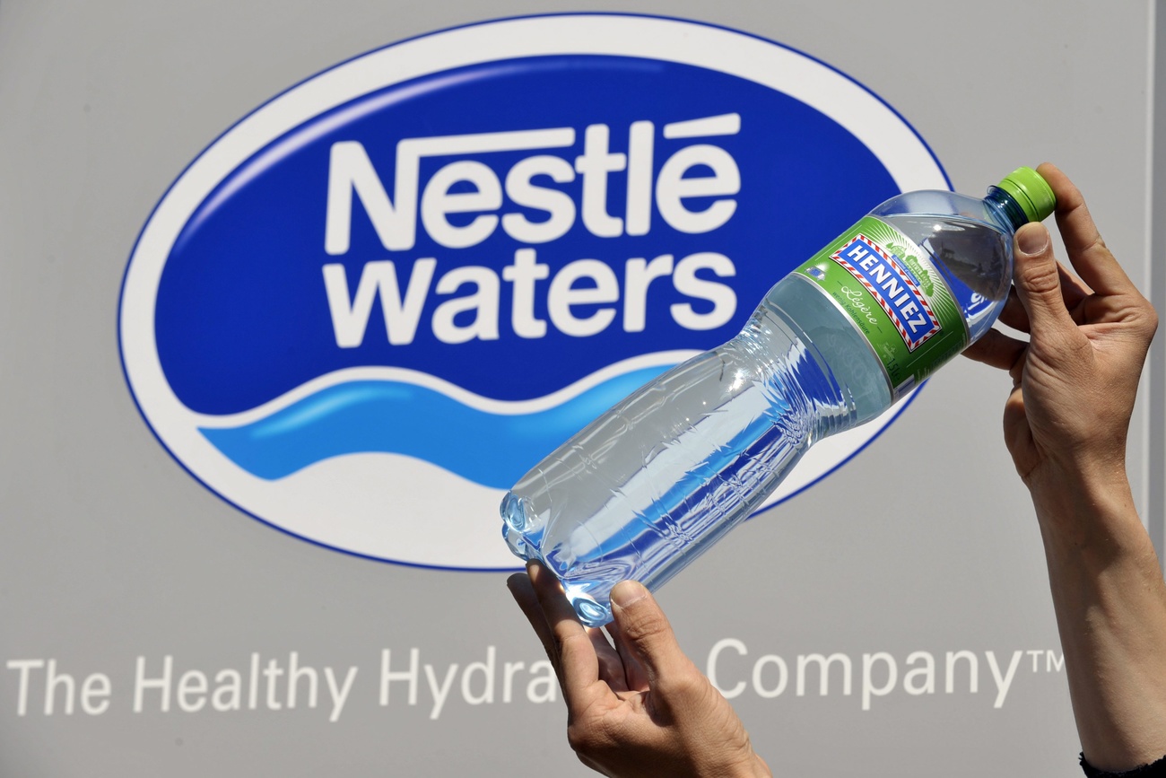 logo nestle waters con bottiglia di acqua henniez davanti