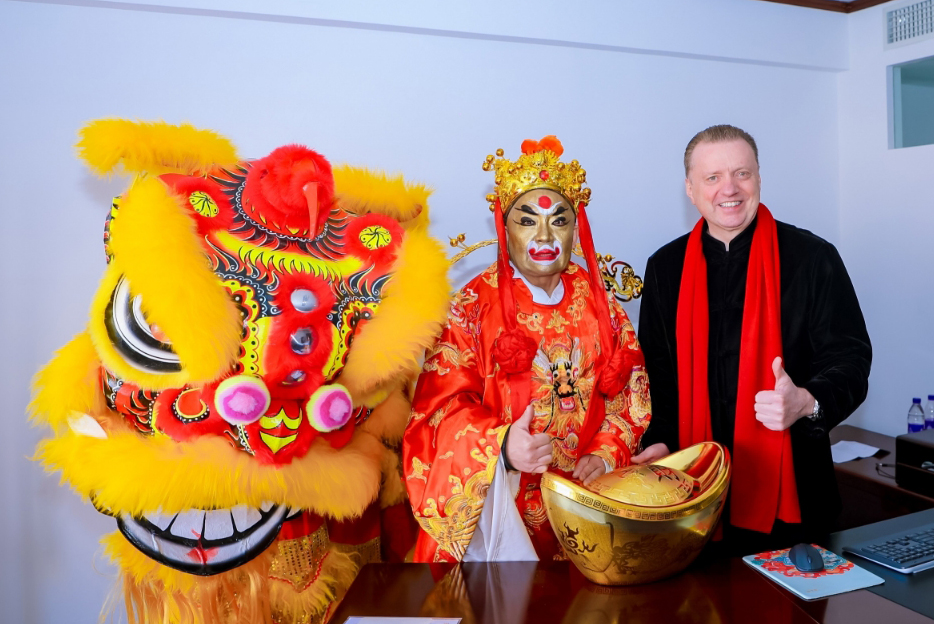 Ein Drache, ein verkleideter Mann und ein Mann mit rotem Schal