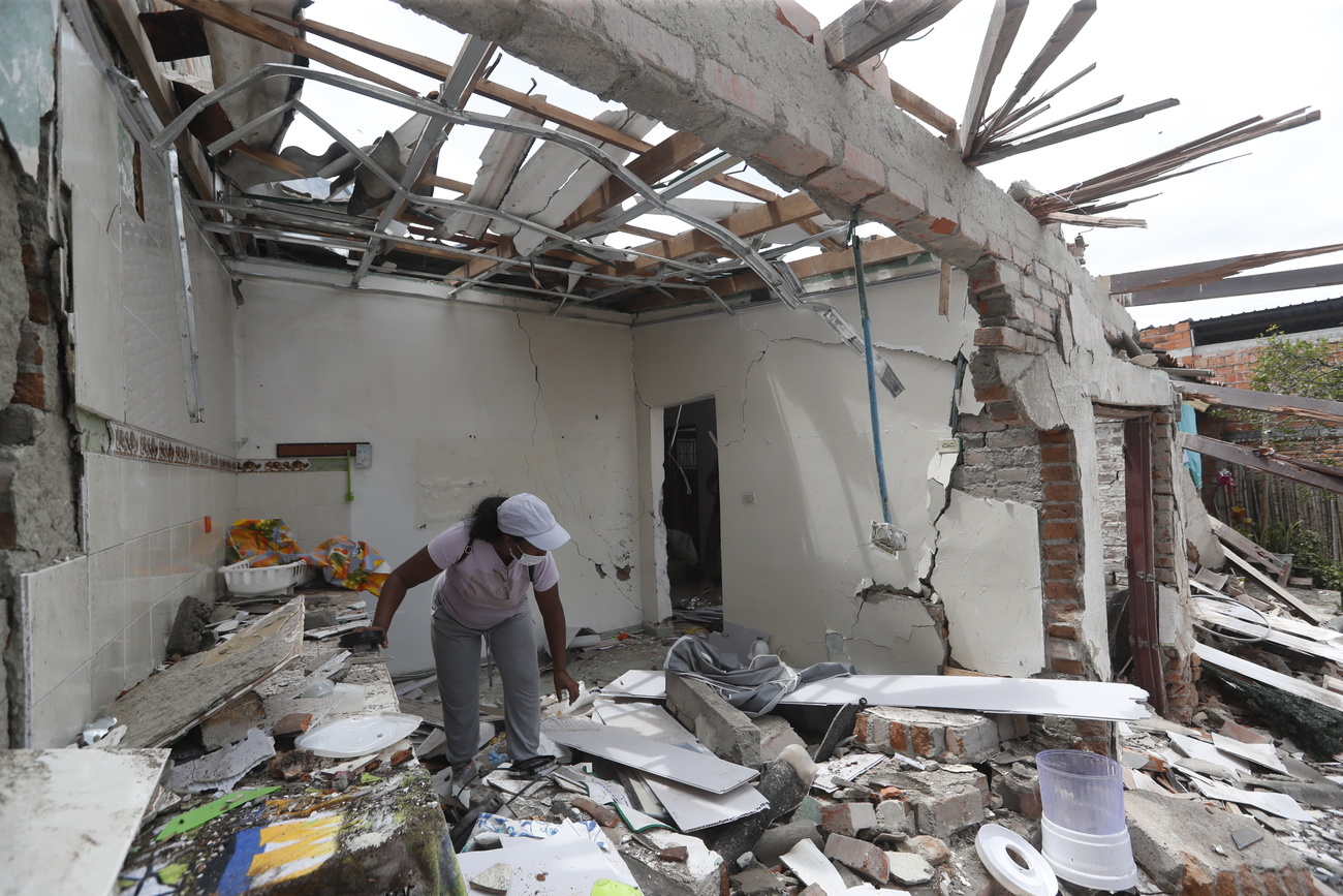 A person searches through the rubble of a house affected by an explosion in Mondomo, Cauca, Colombia, 17 April 2025.
