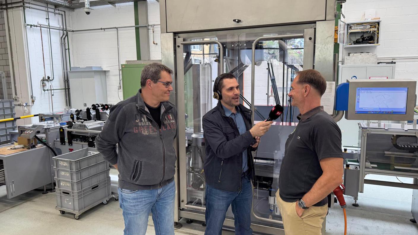 Le correspondant de la RSI s'entretient avec André Seiler (à droite), directeur de l'entreprise, et Beat Gilomen, responsable de production au siège de Plaque Suisse SA, à Nunnigen.