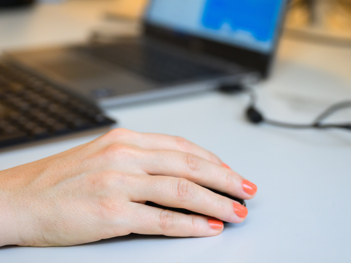 dona lavora al pc, primo piano della mano sul mouse